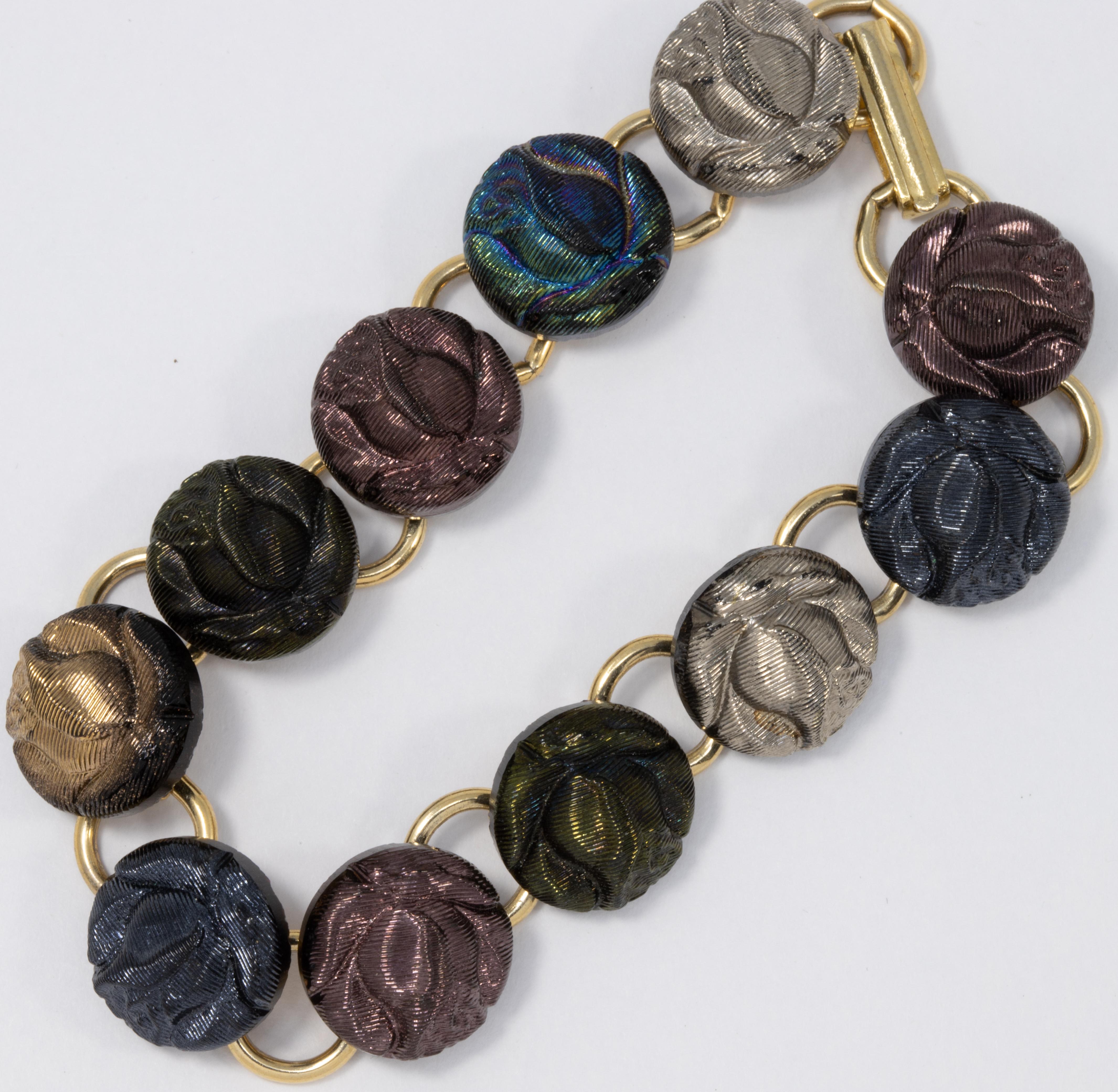 An elegant vintage bracelet, featuring metallic rose links in violet, azure blue, silver, forest green, and iridescent colors. Gold-tone finish.

