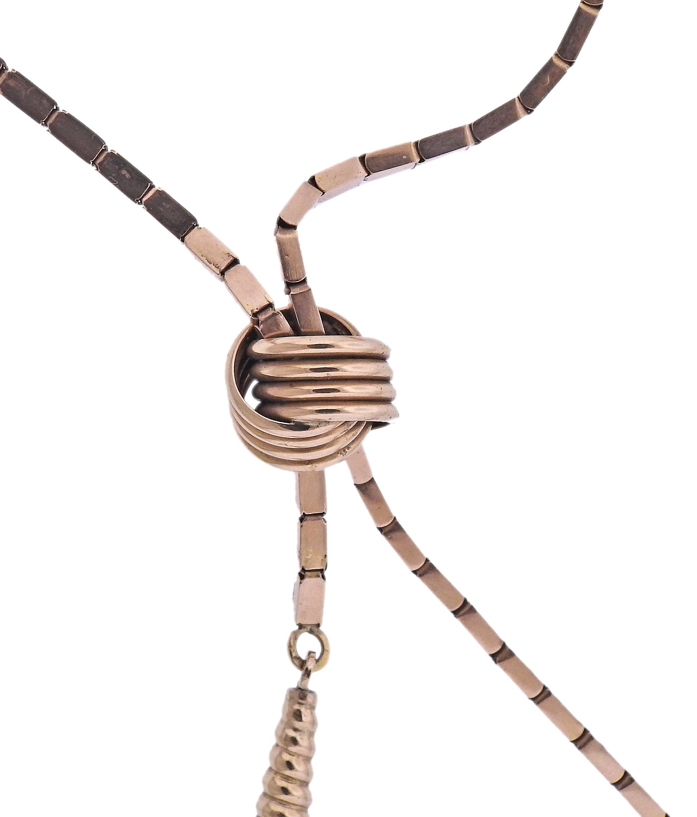 Sautoir rétro en or rose 14k avec pendentif pompon, avec nœud coulissant. Le collier fait 27