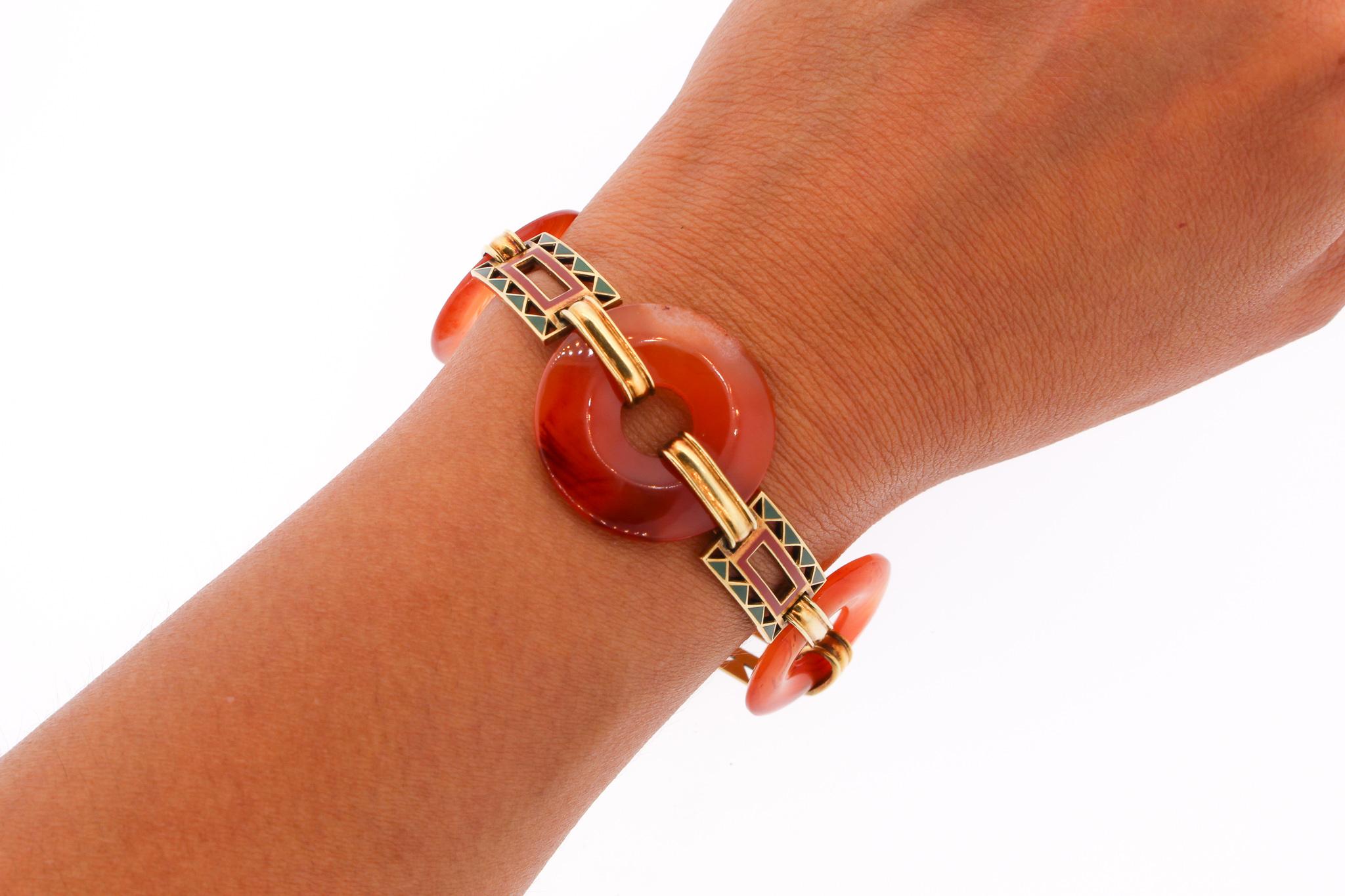 A vintage large round donut carnelian link bracelet with rectangular gold links in 14k gold circa 1940. The links have orange and green enamel in a zig zag pattern. The colors compliment the orange carnelian. The bracelet dates to the late 1940s