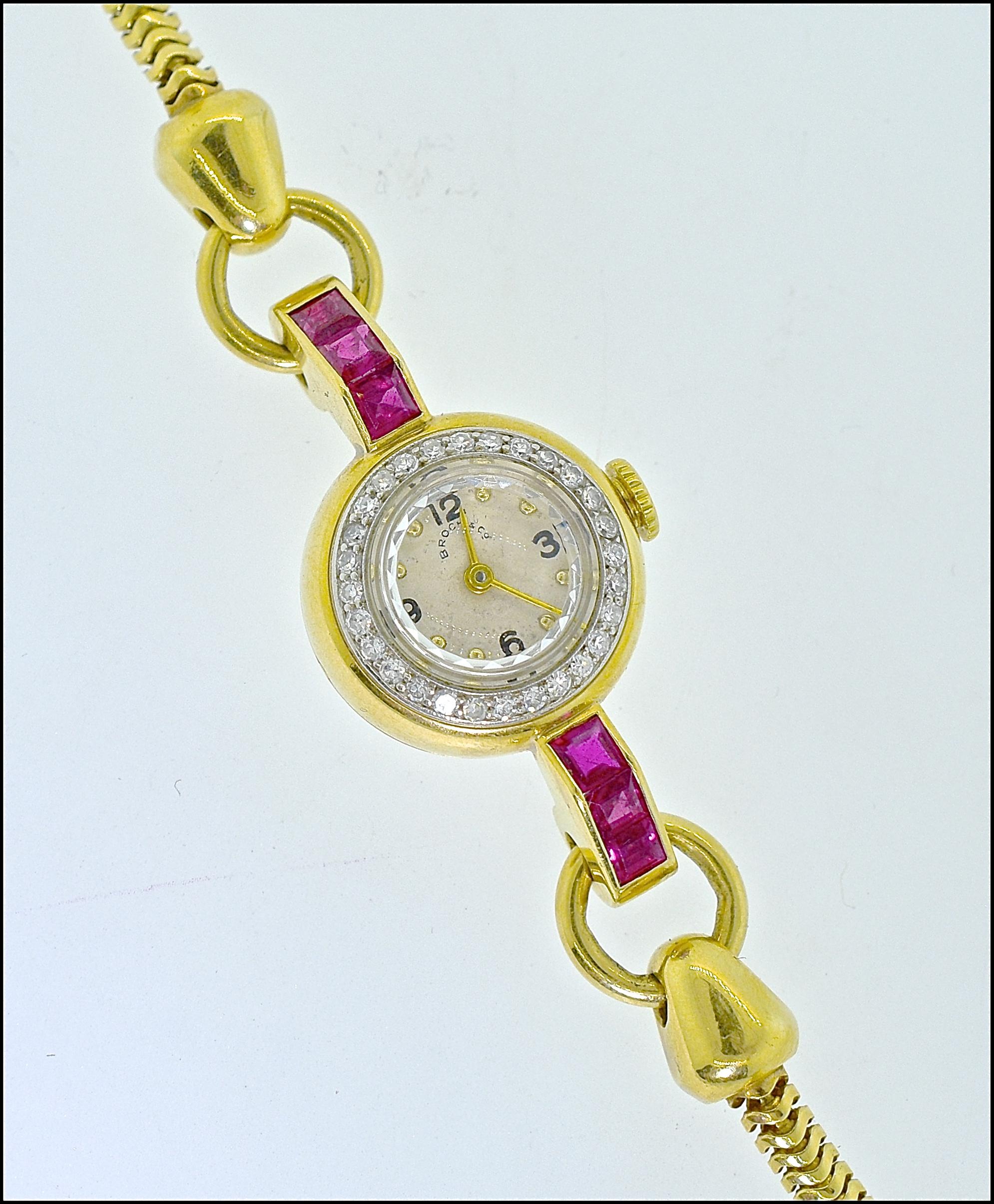 Retro vintage ladies wrist watch  by Brock, this watch   has a strong retro, Art Moderne, design. There are 6 fine natural rubies, probably unheated Burma stones, as evident of their fine  color.  There are diamonds surrounding the diamond.  The 17