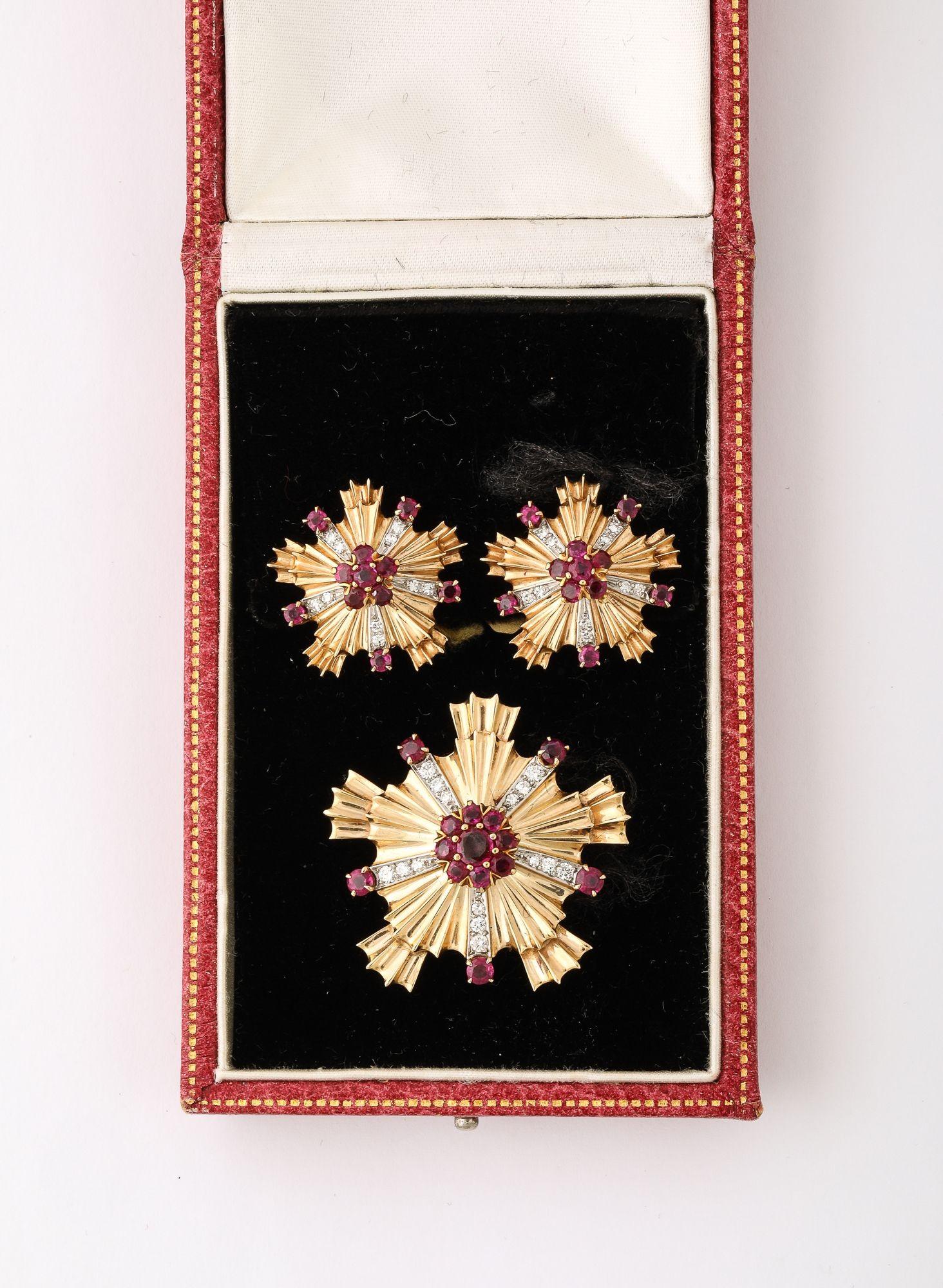 A stunning 3-piece vintage suite crafted from 14kt yellow gold, featuring a striking starburst design with ruby and diamond accents. This exquisite set, aptly described as a Retro Ruby, Diamond and 14k Gold Earring and Brooch Set, includes both a