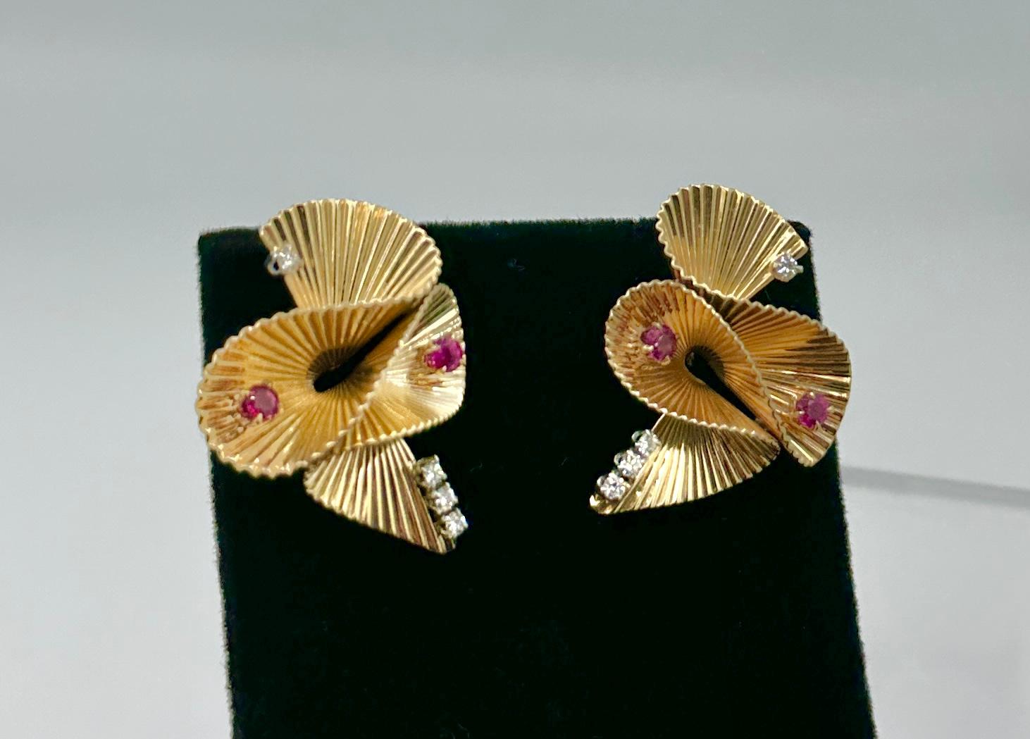 Il s'agit d'une paire spectaculaire de boucles d'oreilles rétro en diamant et rubis avec quatre rubis magnifiques et huit diamants blancs étincelants d'une grande beauté sertis dans un motif de ruban tourbillonnant en or 14 carats.  Les boucles