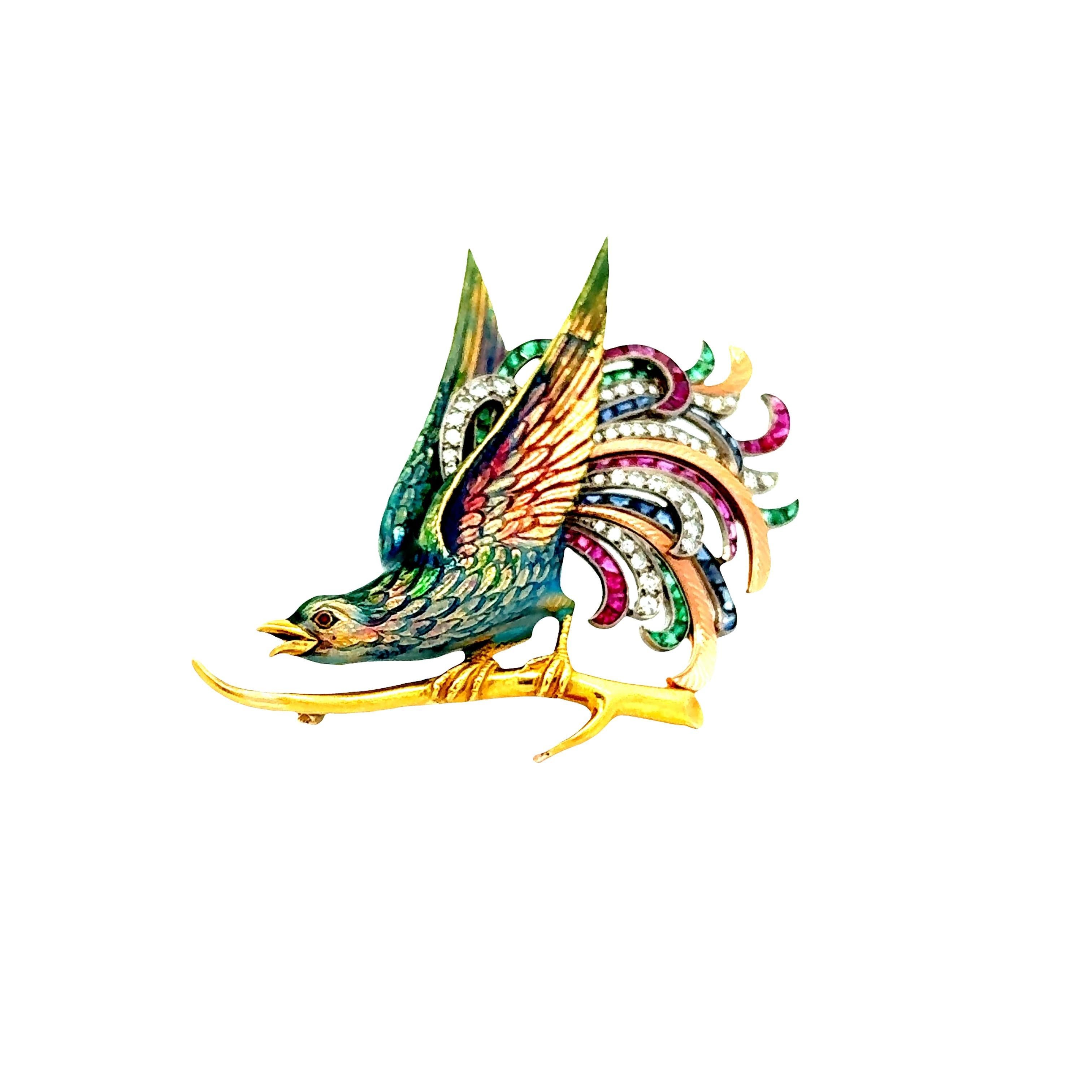 Une broche étonnante de la fin des années 1930 représentant un oiseau vibrant perché sur une Branch dorée, réalisée en or jaune 18k. Les ailes et la queue de l'oiseau sont ornées de rubis, d'émeraudes et de saphirs en forme de carrés, ainsi que de