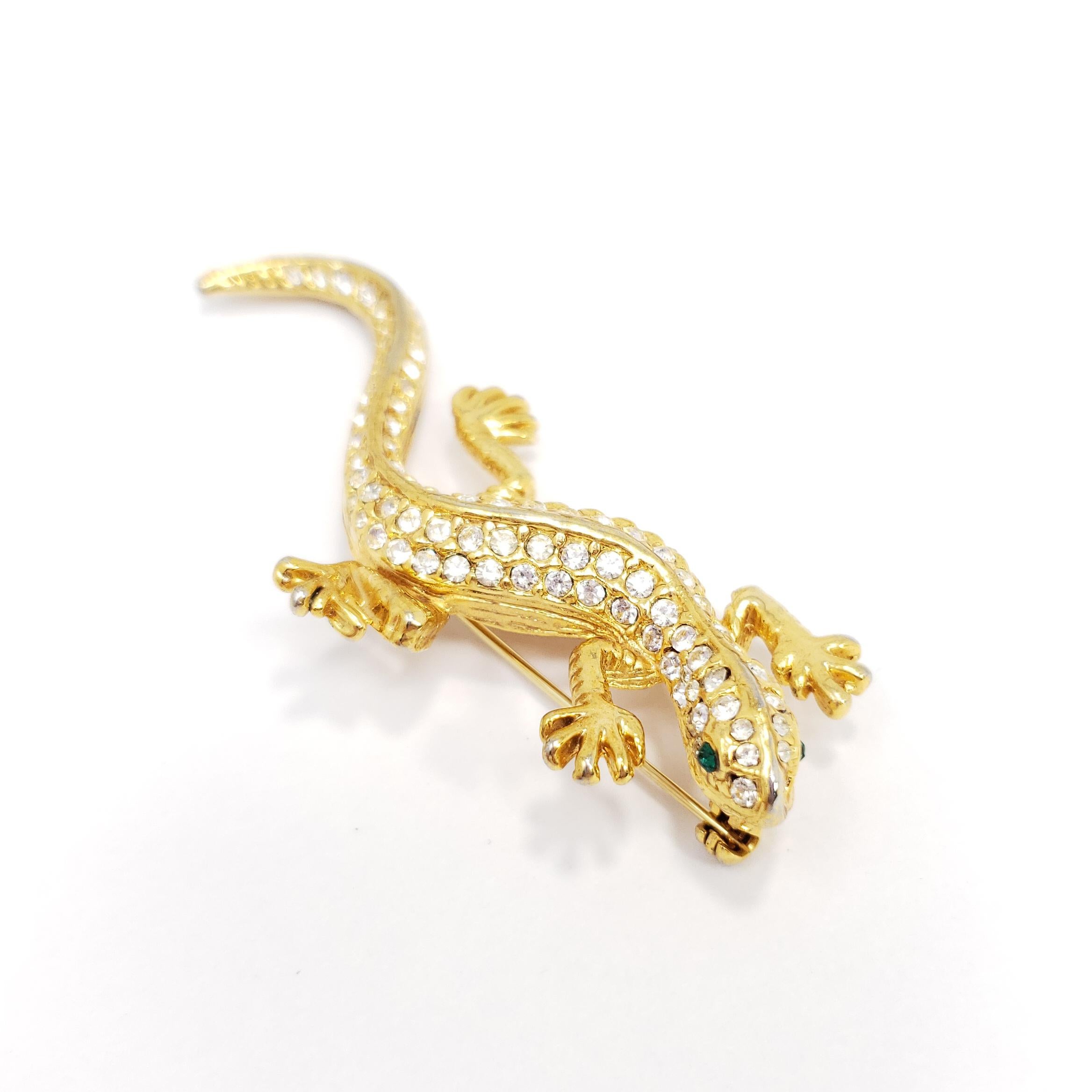 Cette salamandre élégante est décorée de cristaux clairs étincelants et d'yeux de couleur émeraude. Une broche rétro glamour avec une finition dorée brillante !

Marques / poinçons / etc : USA

Une pièce vintage, comme neuve, non portée, de haute
