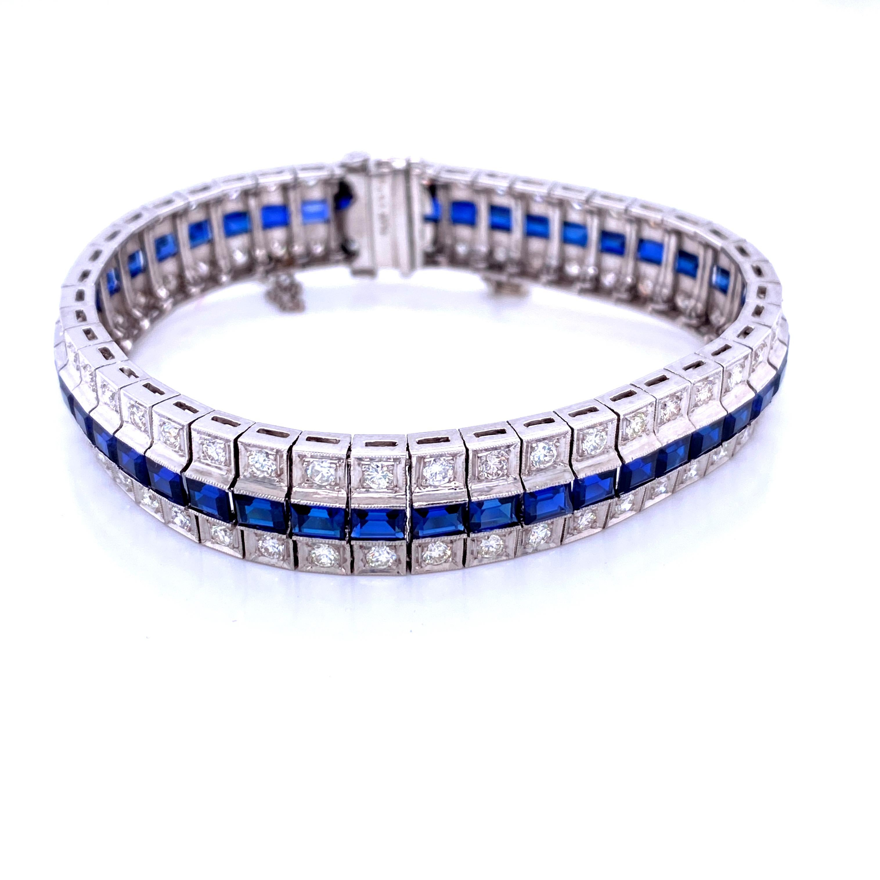 One platinum (stamped PLAT 5978) bracelet set with 4x3mm emerald cut synthetic sapphires in a center row with a row of round brilliant diamonds on either side, approximately 1.75 carats total weight with matching H/I color and VS2/SI1 clarity.  The