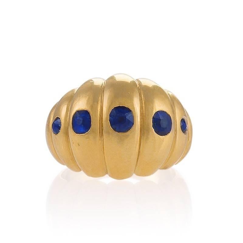 A Retro 18 karat gold ring with sapphires. The bombé ring has 5 old European-cut sapphires with an approximate total weight of .80 carat. The sapphires are gypsy set in the centers of the 5 convex tapered scallops.  Circa 1930's.

Ring size 7-1/4;