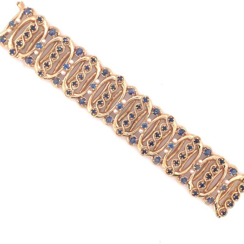 One Retro sapphire and pearl 14K rosey yellow gold bracelet featuring 72 round brilliant cut and cabochon sapphires totaling 15 ct. Further enhanced by 18 white cultured pearls each measuring 3 millimeters in diameter. 32 millimeters wide, and 7