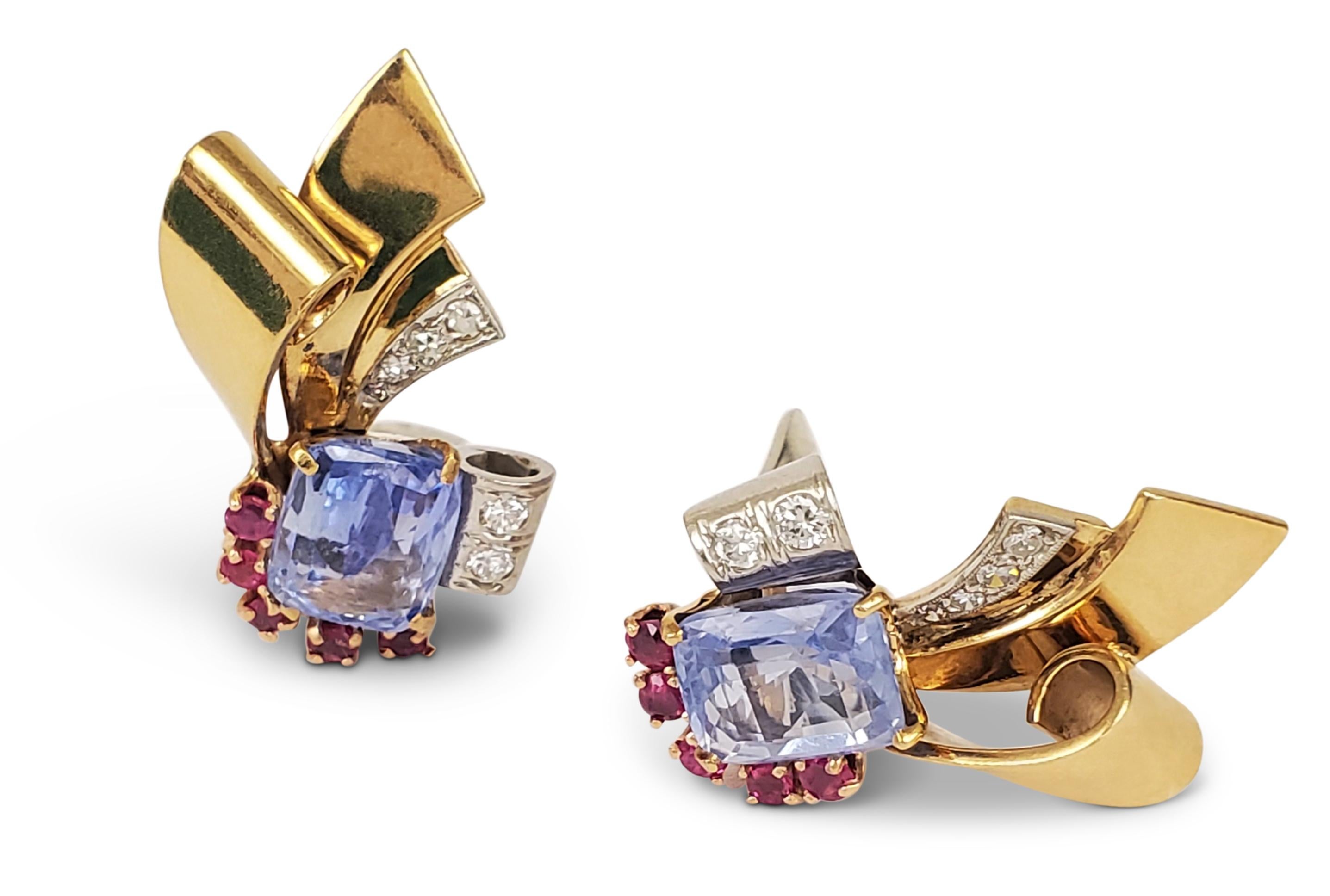 A pair of darling Retro scroll motif earrings crafted in 14 karat yellow gold and platinum. The earrings are set with pastel blue colored sapphires weighing an estimated 6.00 carats in total and flanked by 0.50 carats of rubies. The earrings are