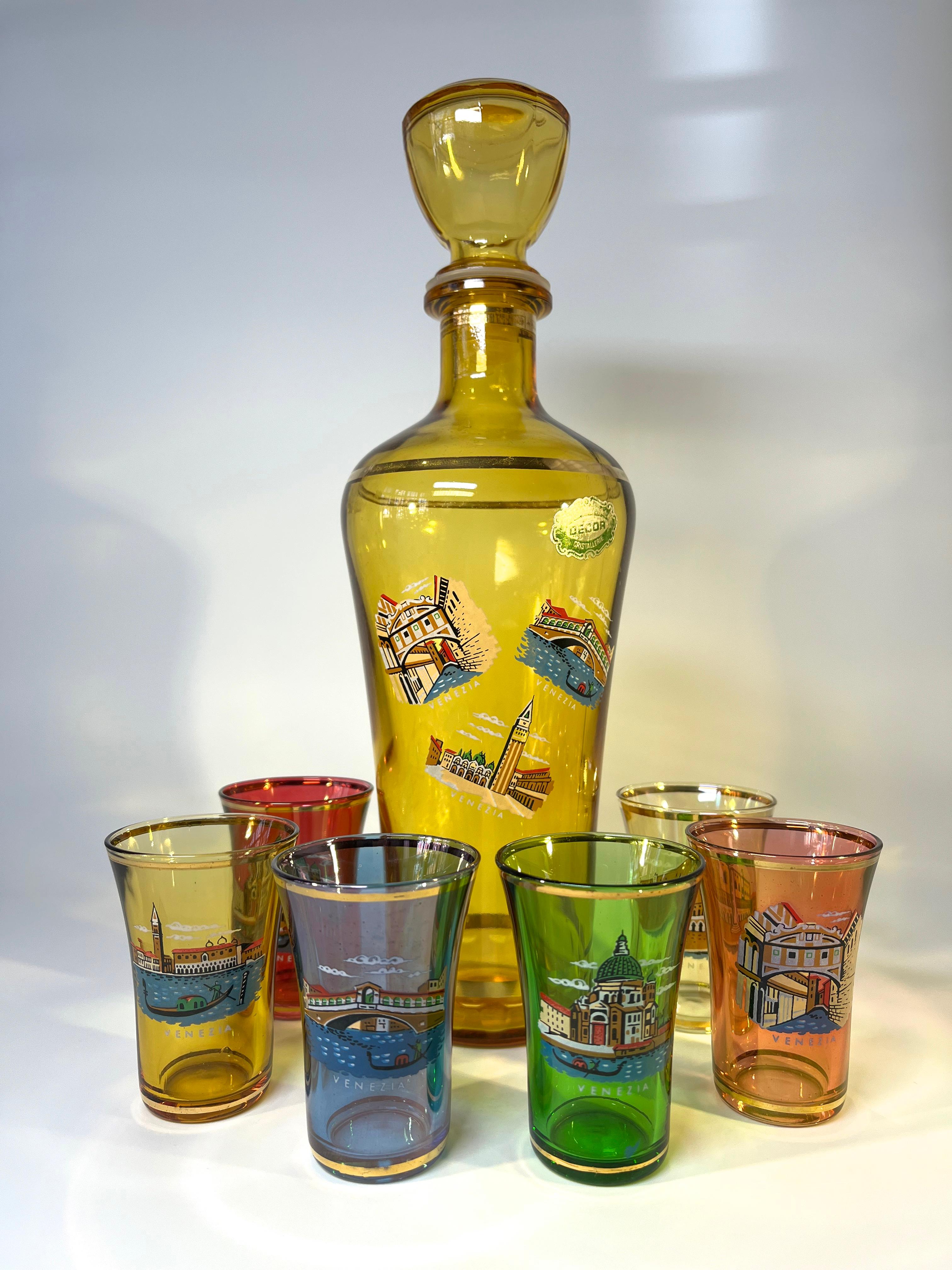 Nostalgic glass decanter and six glasses depicting the famous sights of Venice
Fabulously retro and kitsch - a collectors piece
Amber coloured decanter with enamel scenes of Venice, complete with plastic stopper of the era.  
Six Venetian scenes