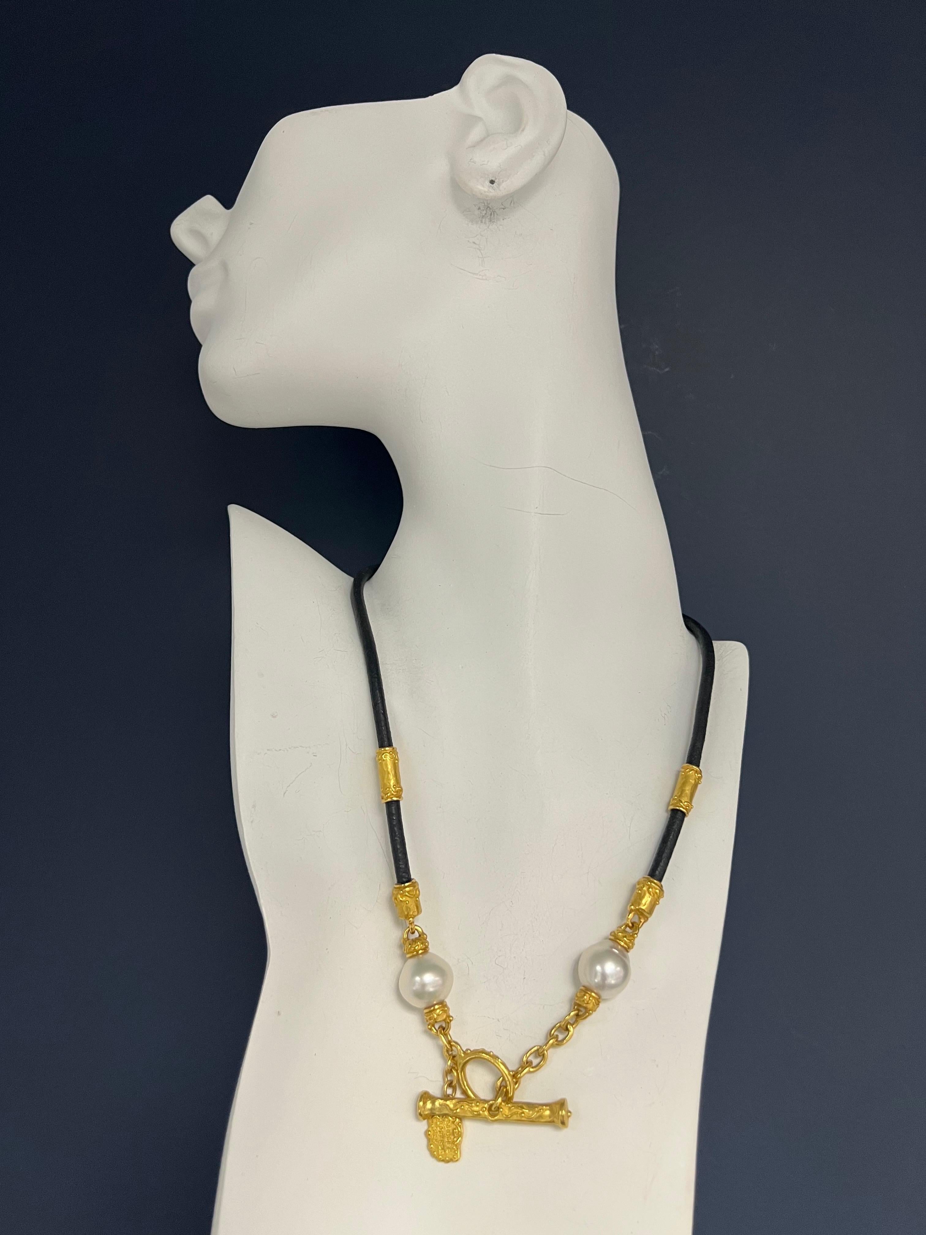 An original signed Denise Roberge 22k Yellow Gold necklace set with two White South Sea pearls, one is 13mm and the other is14mm in diameter. The luster is excellent. The necklace is set with a 22k Yellow Gold Toggle clasp. Total length is 17.5”