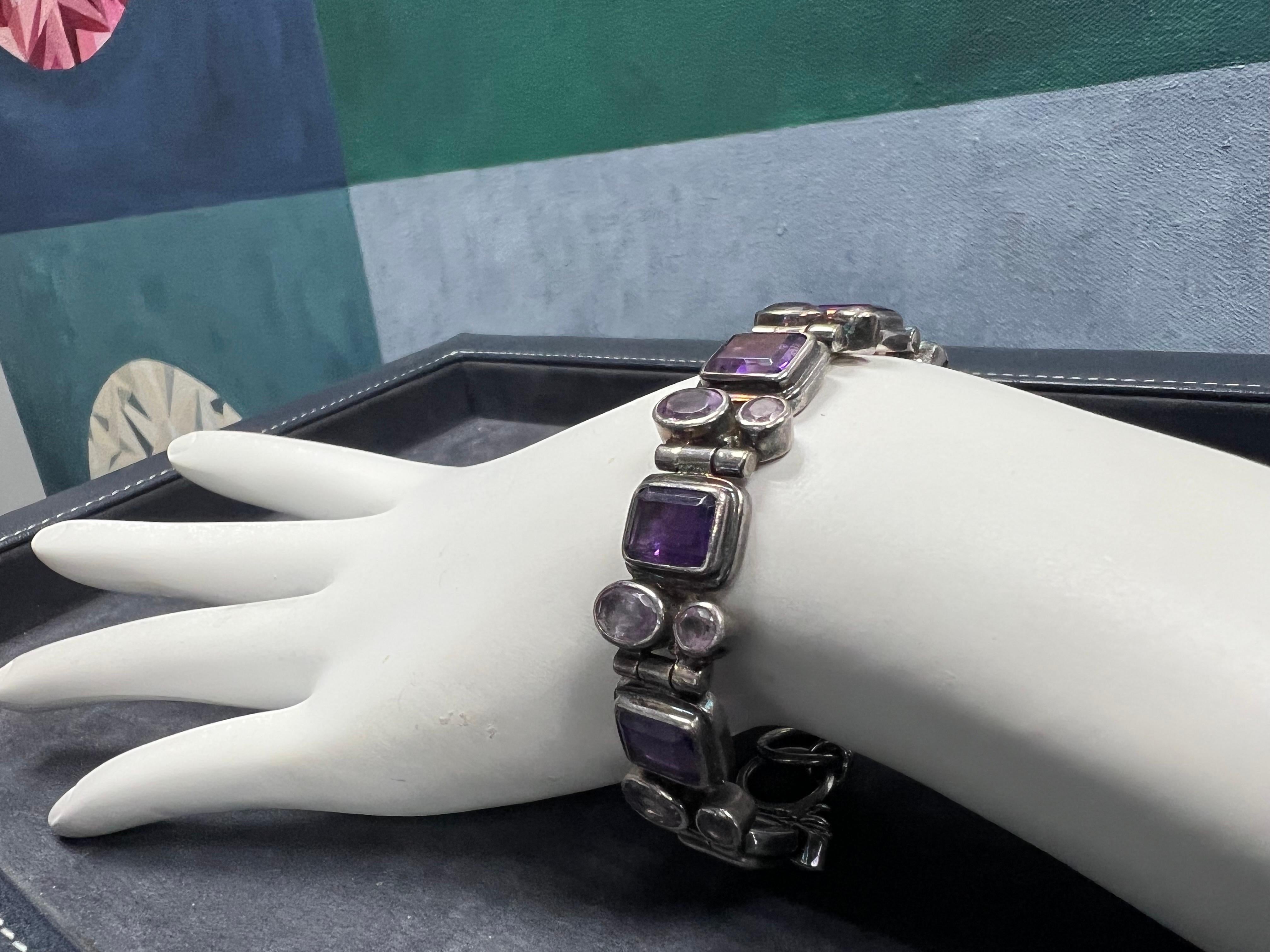 A magnificent Retro Silver 925 Purple Round Oval & Emerald Cut Amethyst Bracelet Circa 1960

This piece is adjustable in length (the image with a ruler illustrates this) and it weighs 37 grams.