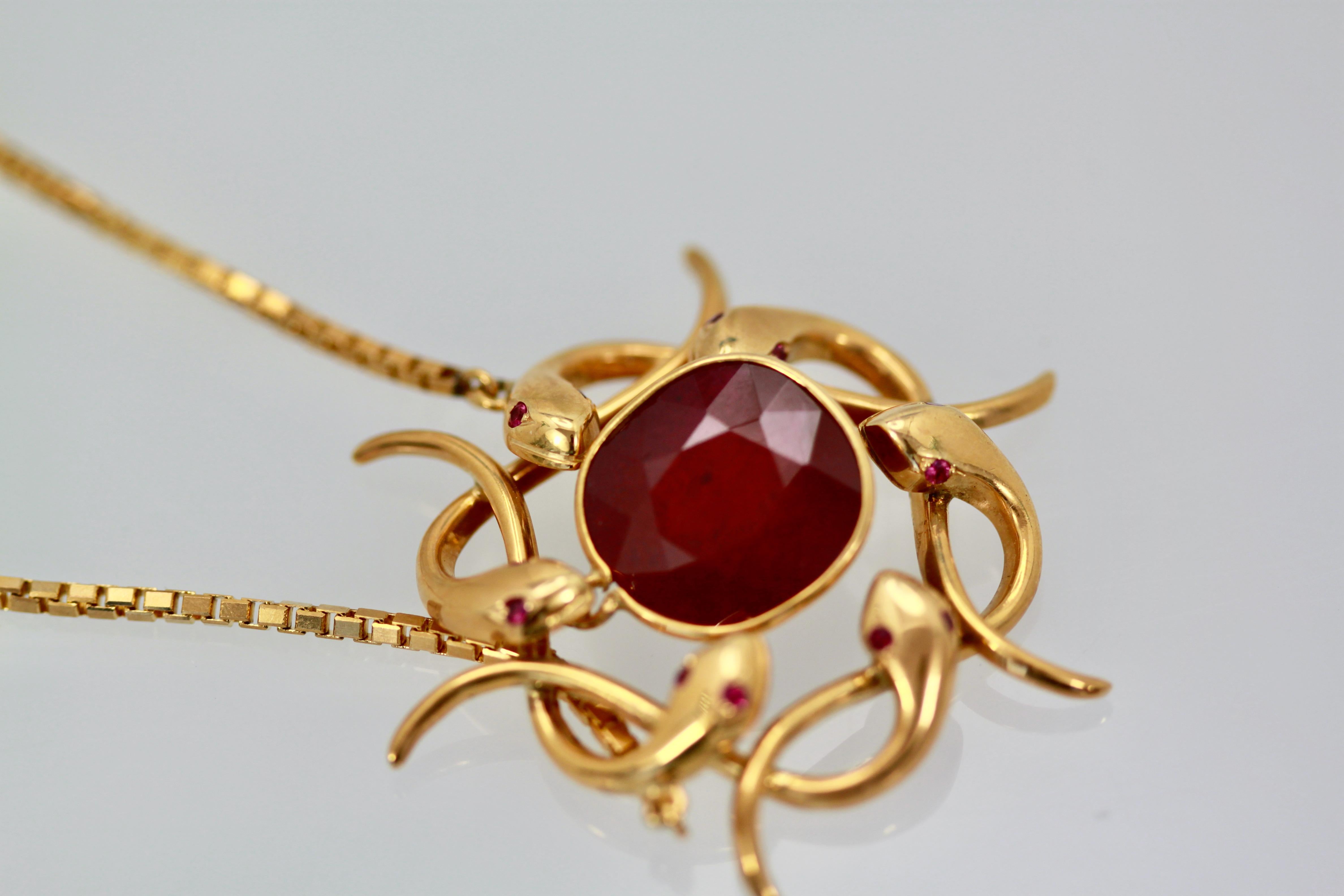 This amazingly unique pendant is a circle wreath made out of 14k yellow gold snakes with ruby eyes (not tested). There are 6 snakes that circle this pendant.  In the center swings a 9+ carat natural African ruby, which is just a gorgeous shade of