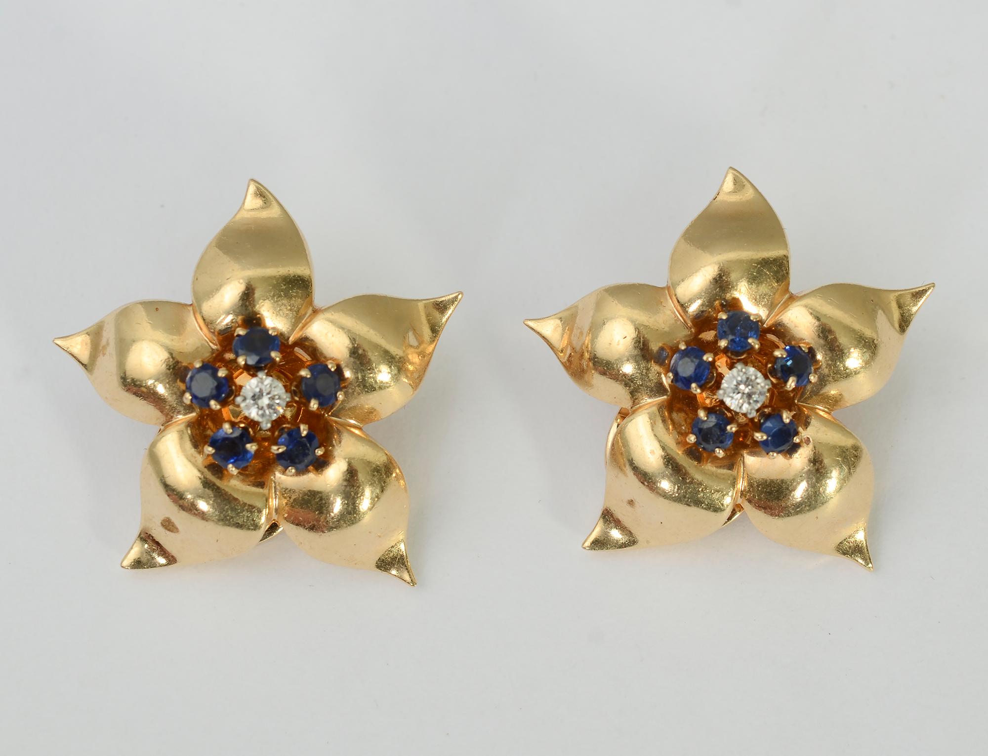 Lovely star-like flower earrings with great form and dimensionality. They are centered with a diamond around which are five sapphires. Clip backs can be converted to posts.