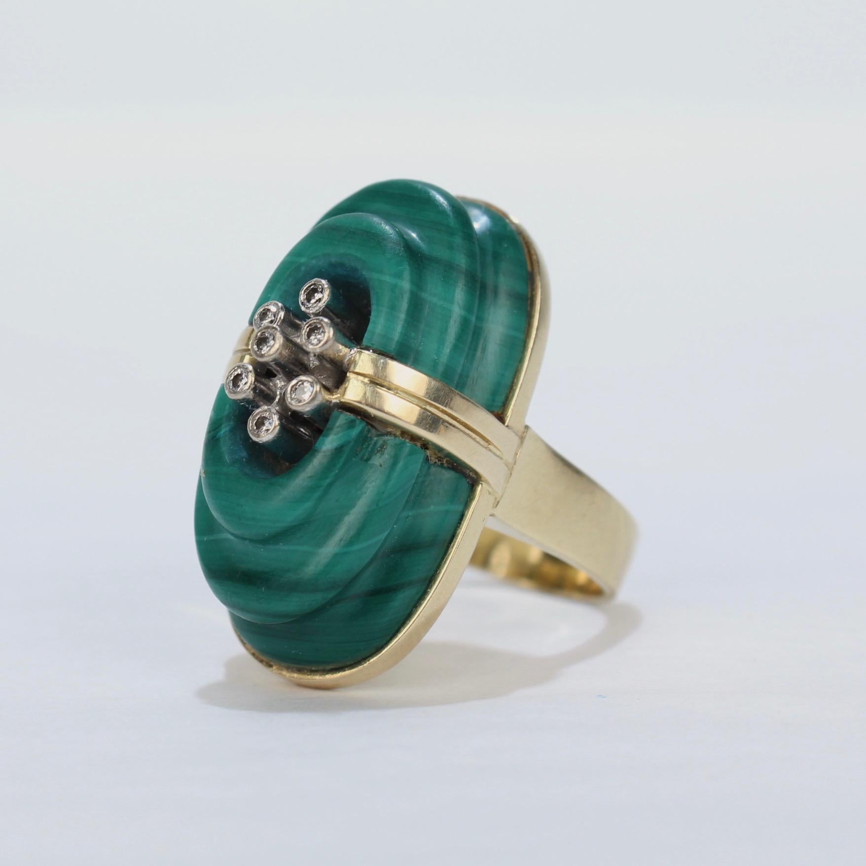 An exciting, retro cocktail ring in 14k gold, malachite and diamonds.

Set with a large, stepped malachite stone and 7 bezel set diamonds. 

Simply a very cool, retro ring with great style! Lots of fun to wear!!

Marked to the shank 14k for gold