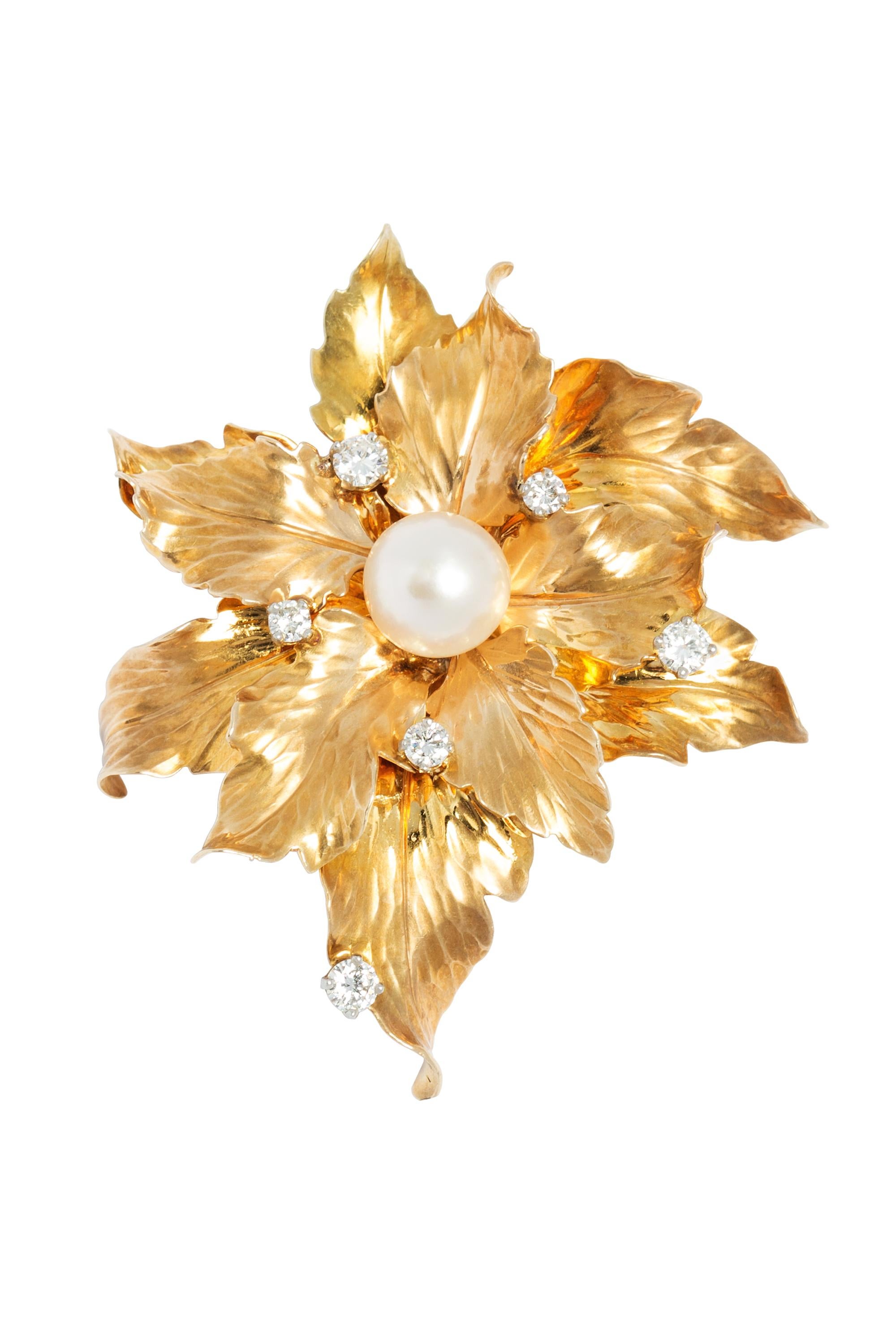 This wonderful large vintage brooch is comprised of an elegant arrangement of glossy leaves rendered in bright 14 karat yellow gold highlighted by six sparkling round brilliant diamonds with a softly gleaming 9 mm cultured pearl at the center. The