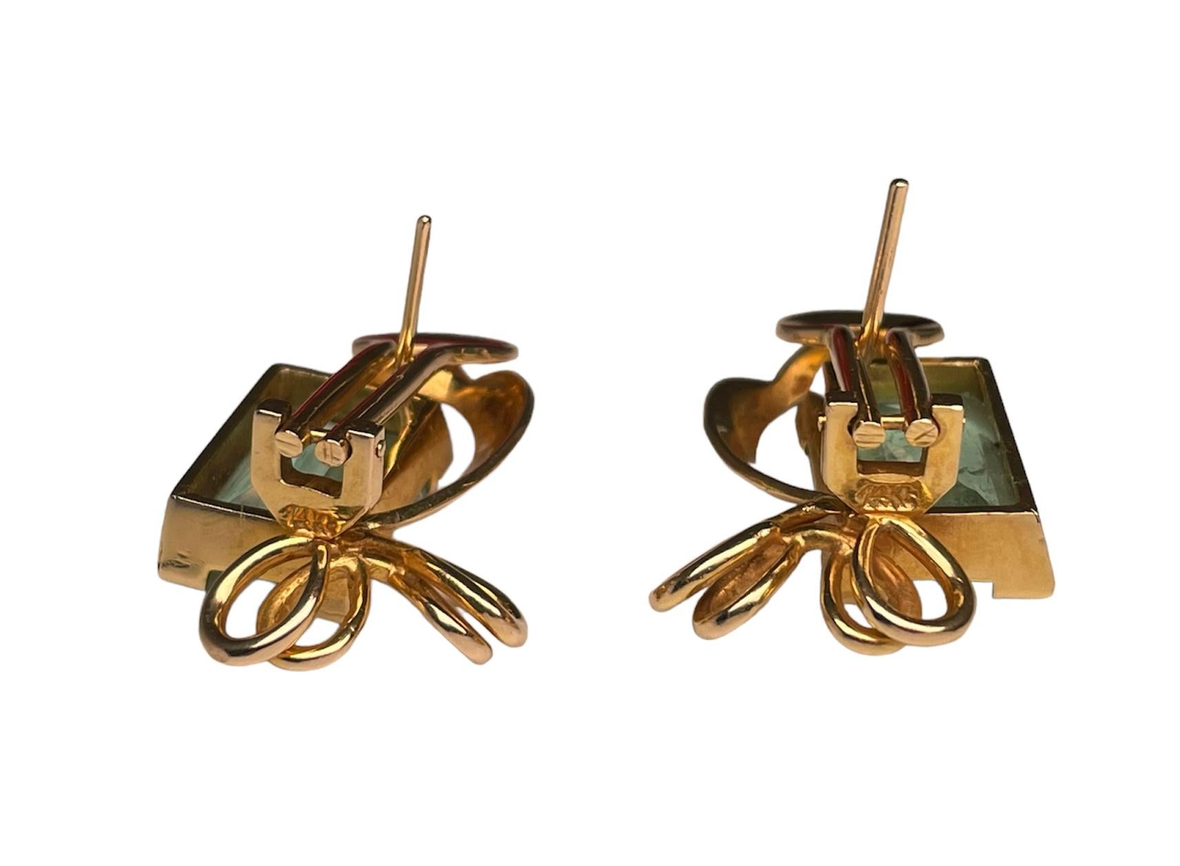 This is a pair of 14k yellow gold emerald earrings. The emeralds have emerald cut. The measurements of one of the emeralds are 14.30 x 9.59 x 5.40 mm and its weights is 4.81 ct. The measurements of the second one are 13.99 x 9.19 x 5.74 mm and its