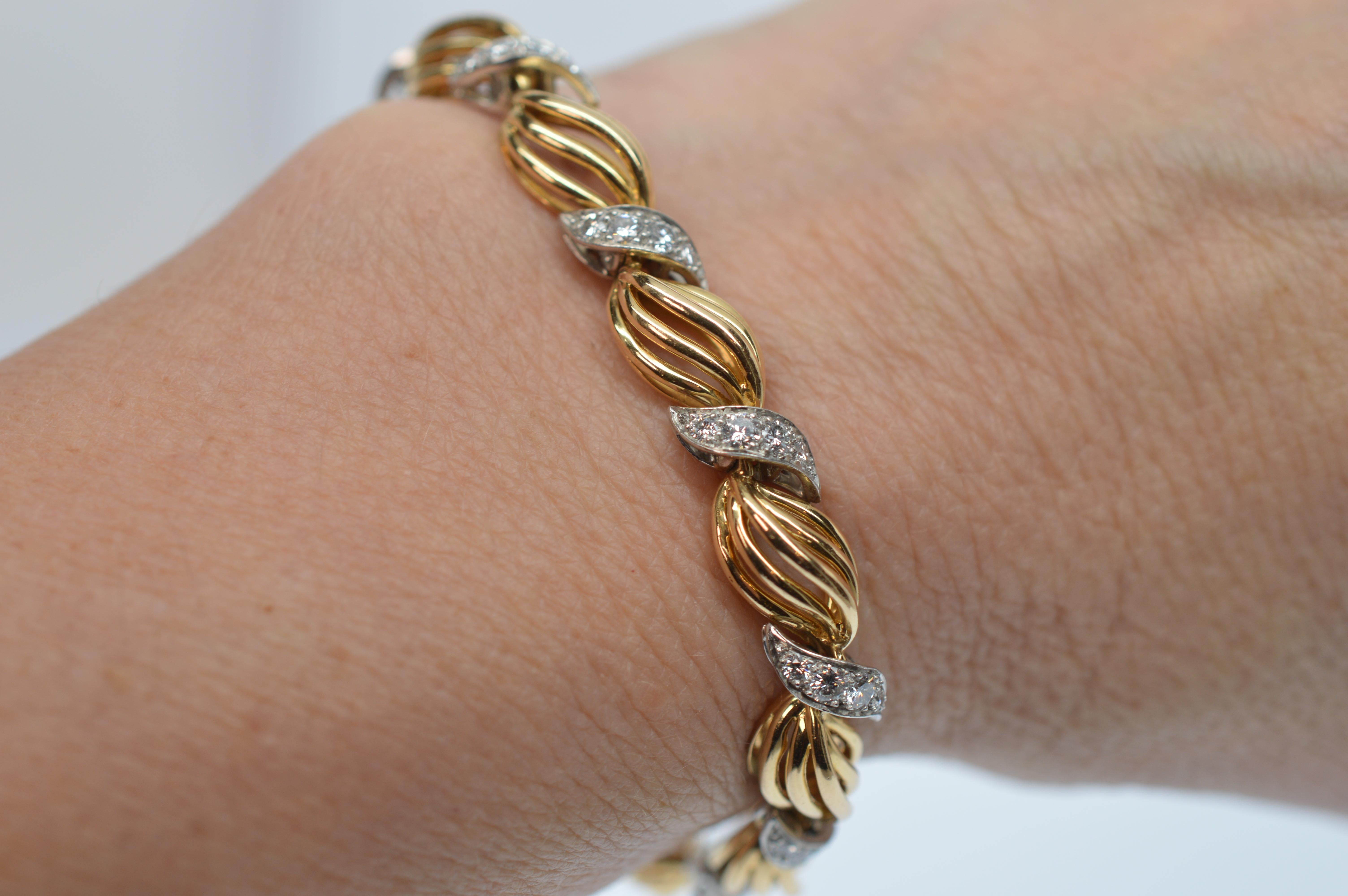 Diamond vignettes adorn this beautifully crafted eighteen karat (18K) yellow gold and platinum retro-style bracelet following in the popular style of Ava & Elizabeth. Measuring seven inches in length and 3/8 in width, the bold 18 karat yellow gold