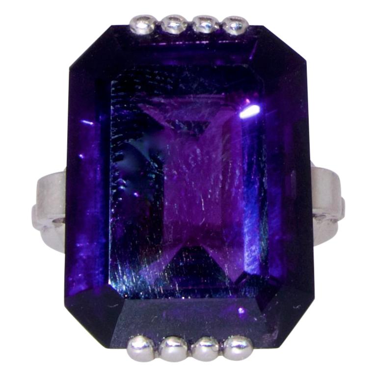 Amethyst, very fine quality,  weighing 16.82 cts, displaying a bright deep purple color with red undertones, set in a geometric hand made platinum ring.  The ring is a size 6 and can be altered easily.  Art Moderne, circa 1950