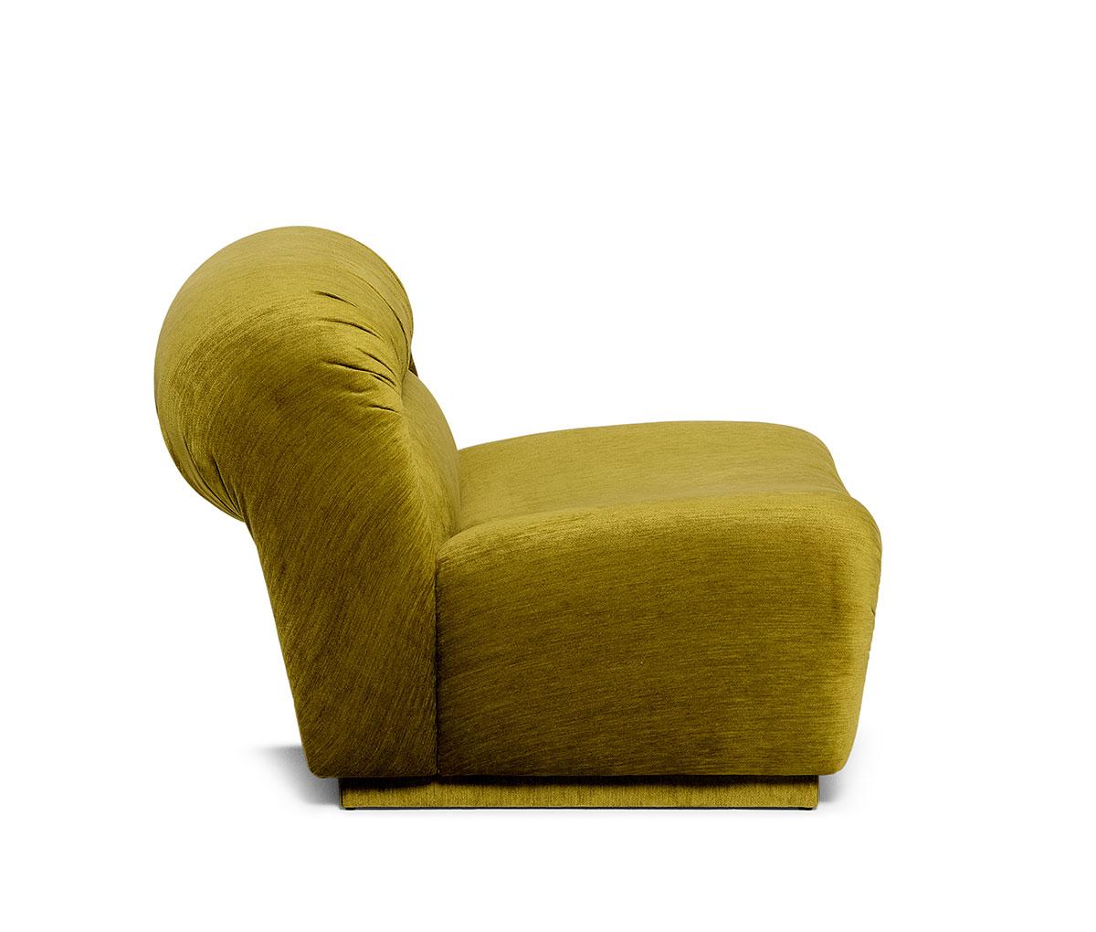 Este sillón muestra una distintiva interacción de textura y color a través de su característica forma curvilínea. Los detalles plisados acentúan las formas suaves y redondeadas del asiento bajo y el respaldo, añadiendo un carácter expresivo.