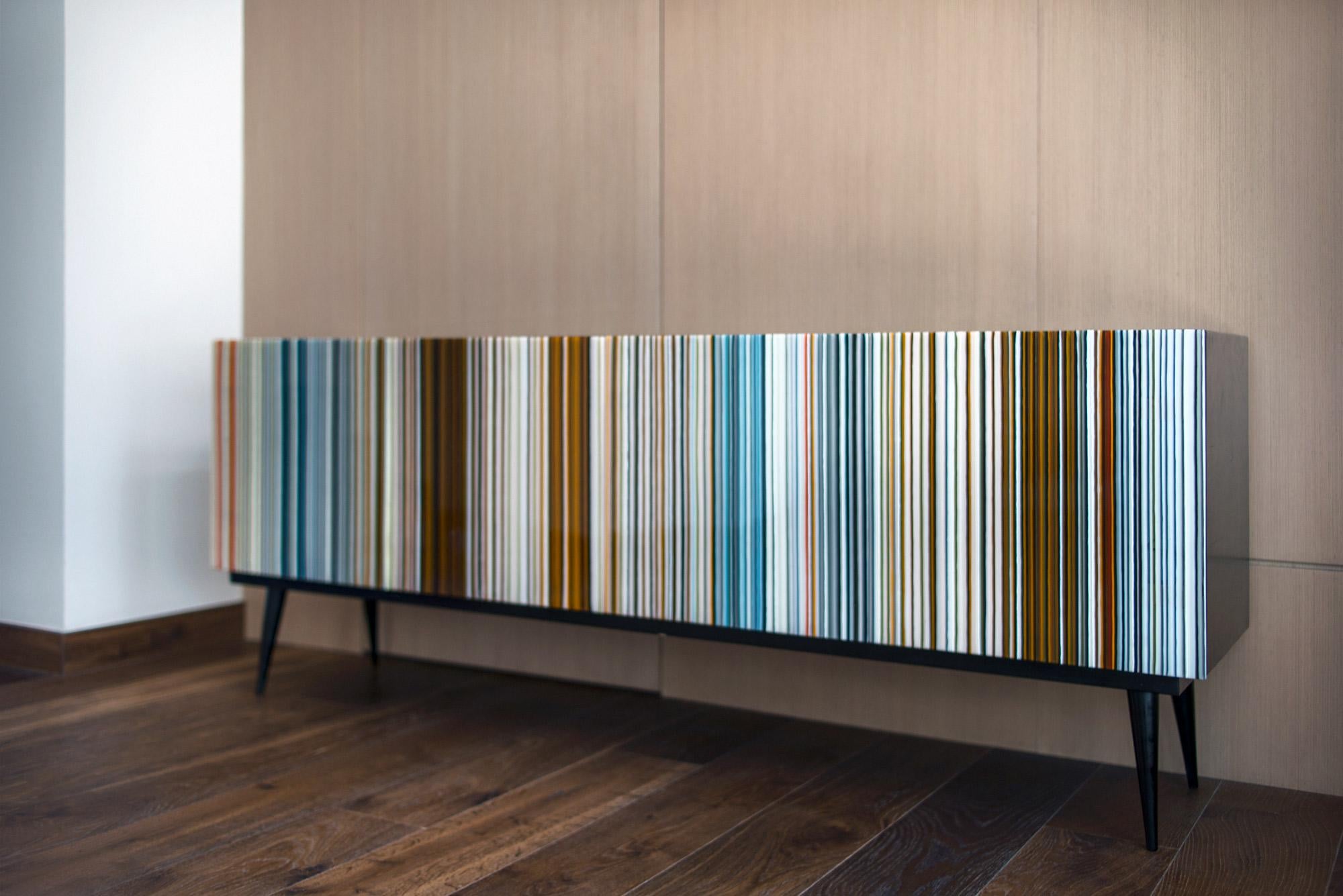 Buff-Heyyy è una credenza in stile retrò progettata da Orfeo Quagliata in collaborazione con Taracea Furniture. Un oggetto in vetro fuso creato con l'esclusiva tecnica del codice a barre. Il design retrò di Buff-Heyyy, unito all'eccezionale