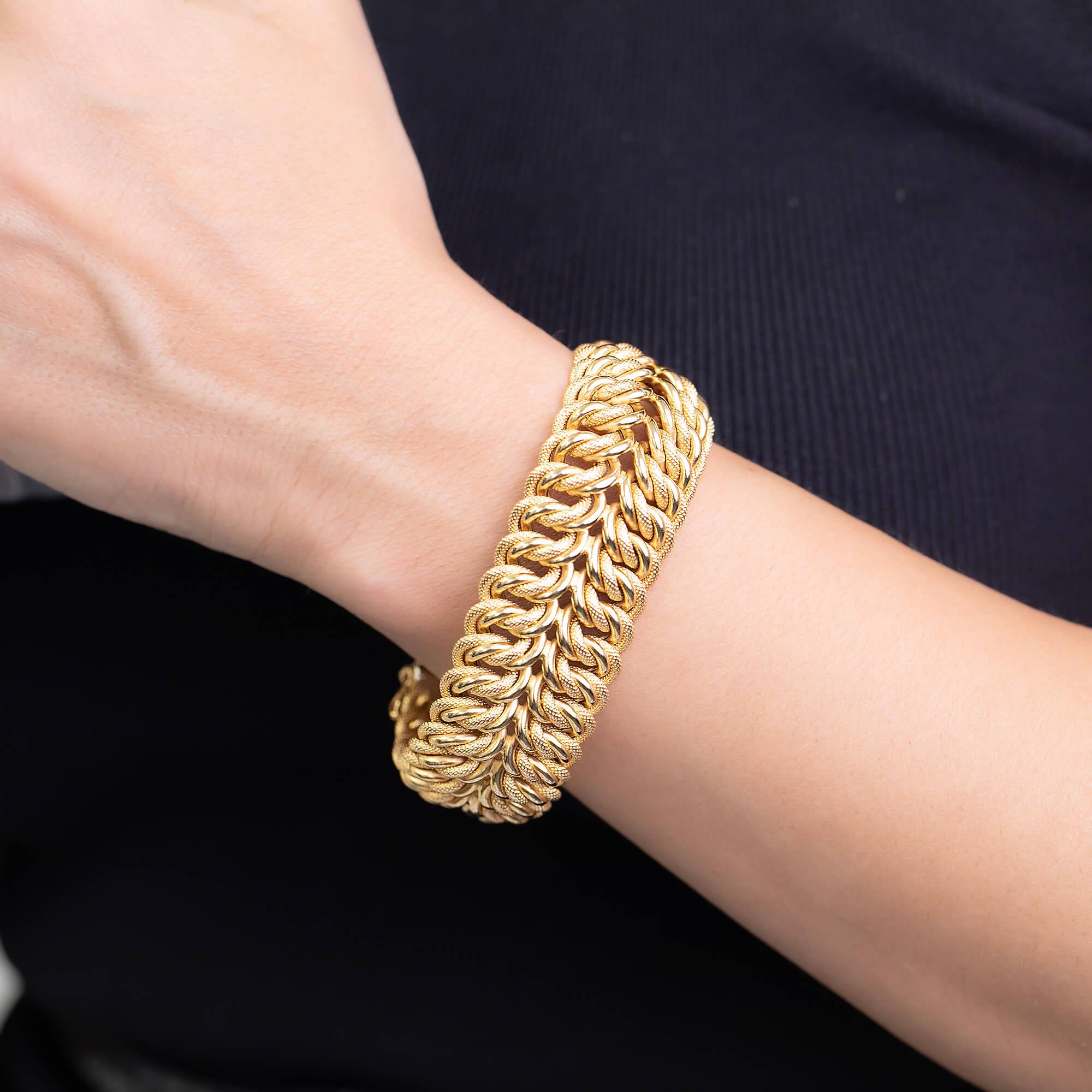 One Retro style 18k yellow gold wide woven bracelet with fancy plain and embossed mesh. This bracelet is secured by large box catch and two figure eight clasps on each side. The clasp is stamped with a with makers mark 