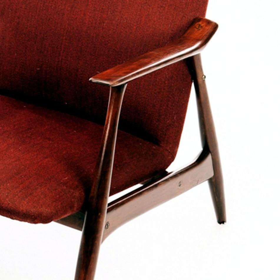 A high back red low slung armchair midcentury.