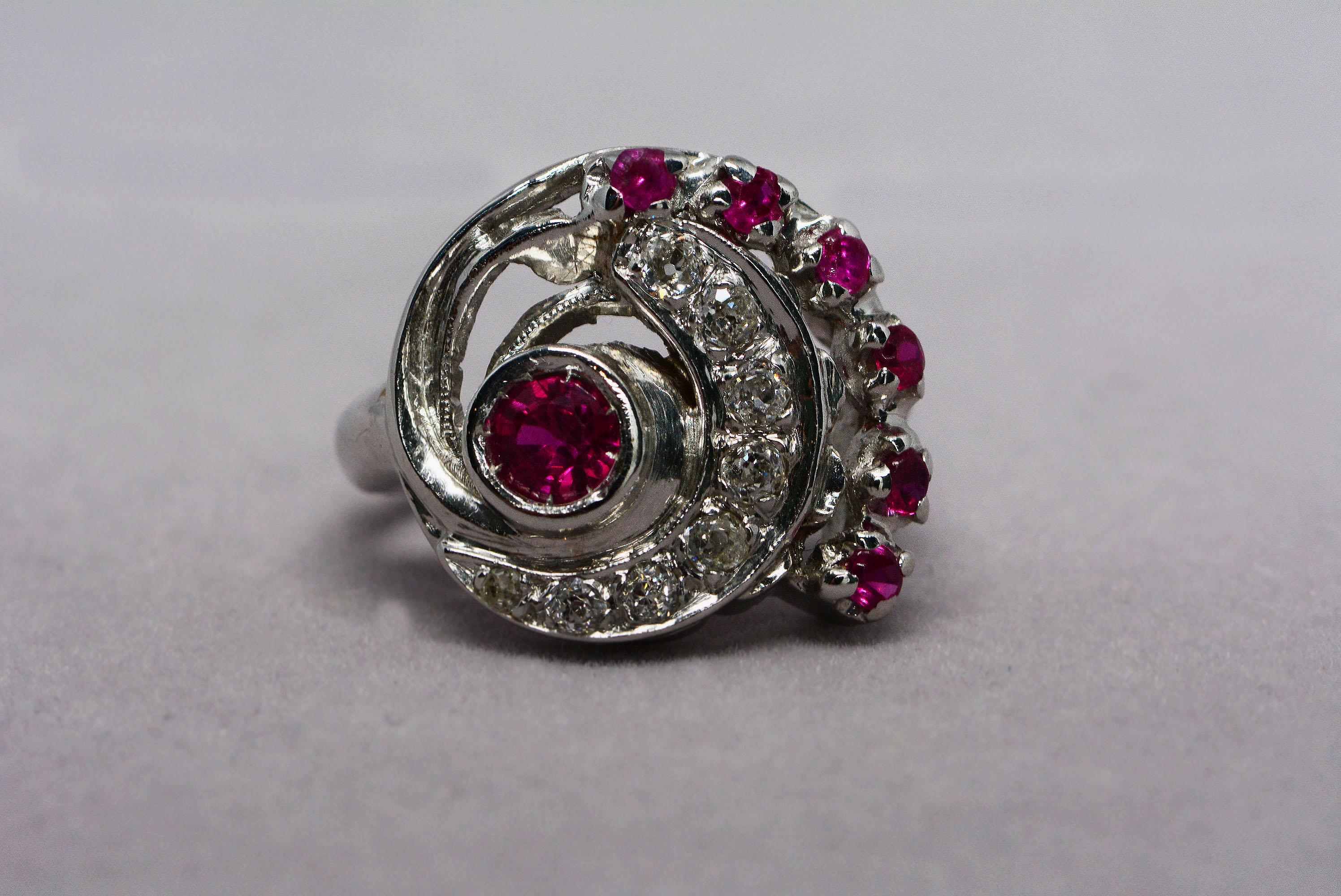 
We love this retro ring!! 
It's handmade from 14 karat white gold and has seven synthetic rubies set into it, and eight diamonds (one single cut and seven old mine cut) that weigh 0.25ctw, I-J colour, Si1-Si2 clarity. 
It's quite heavy and the old