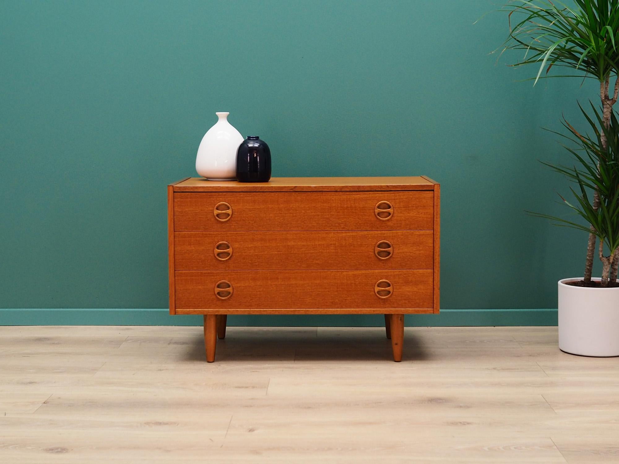 Classic chest of drawers from the 1960s-1970s. Scandinavian design, Minimalist form. Surface finished with teak veneer. Furniture with three drawers. Preserved in good condition (minor bruises and scratches), directly for use.

Dimensions: height
