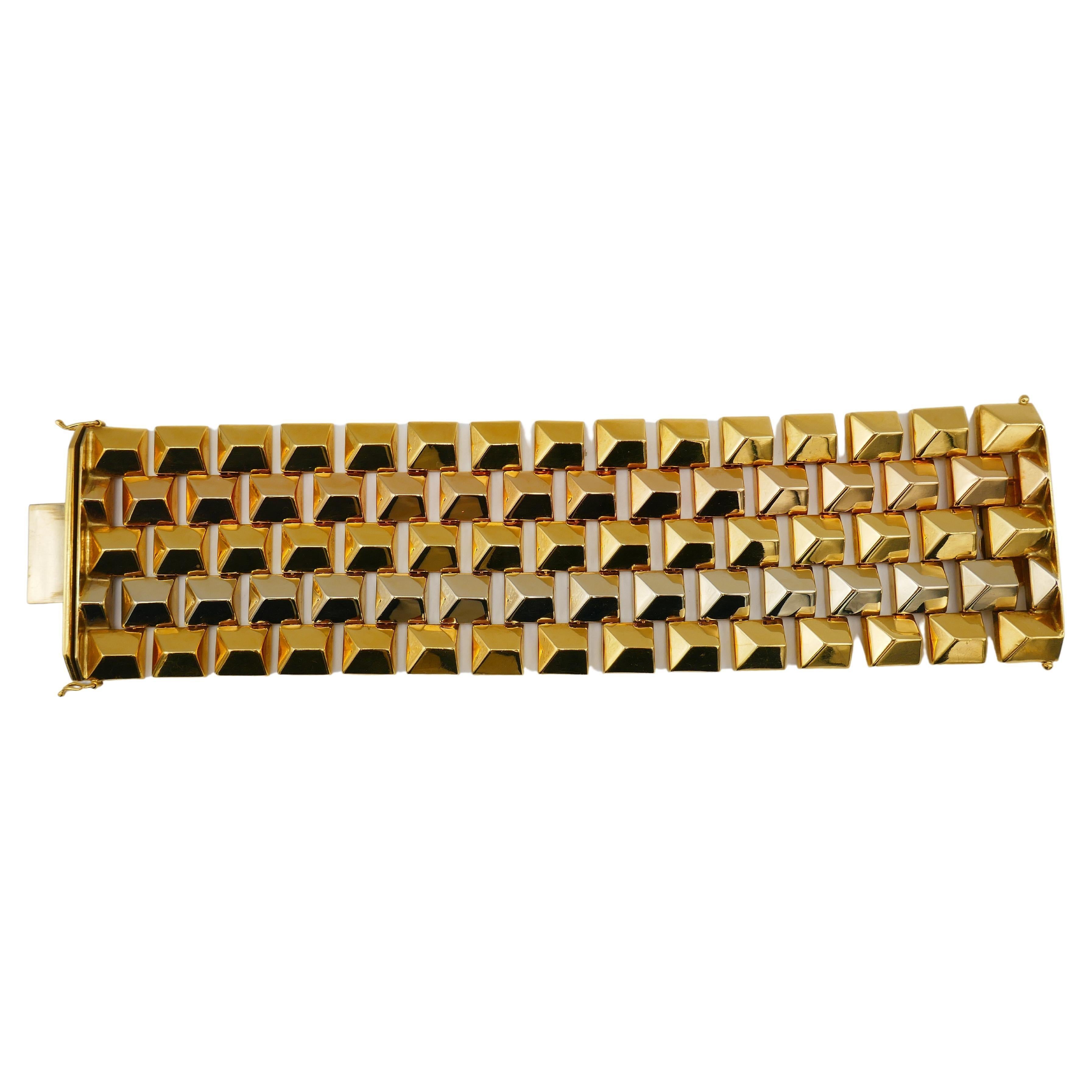 A wide and shiny Retro gold bracelet, made of 18k yellow, white and rose gold. 
This impressive geometrical piece is comprised of the gold square pyramids connected by the invisible hinges. 
The bracelet is silky smooth and flexible. It features