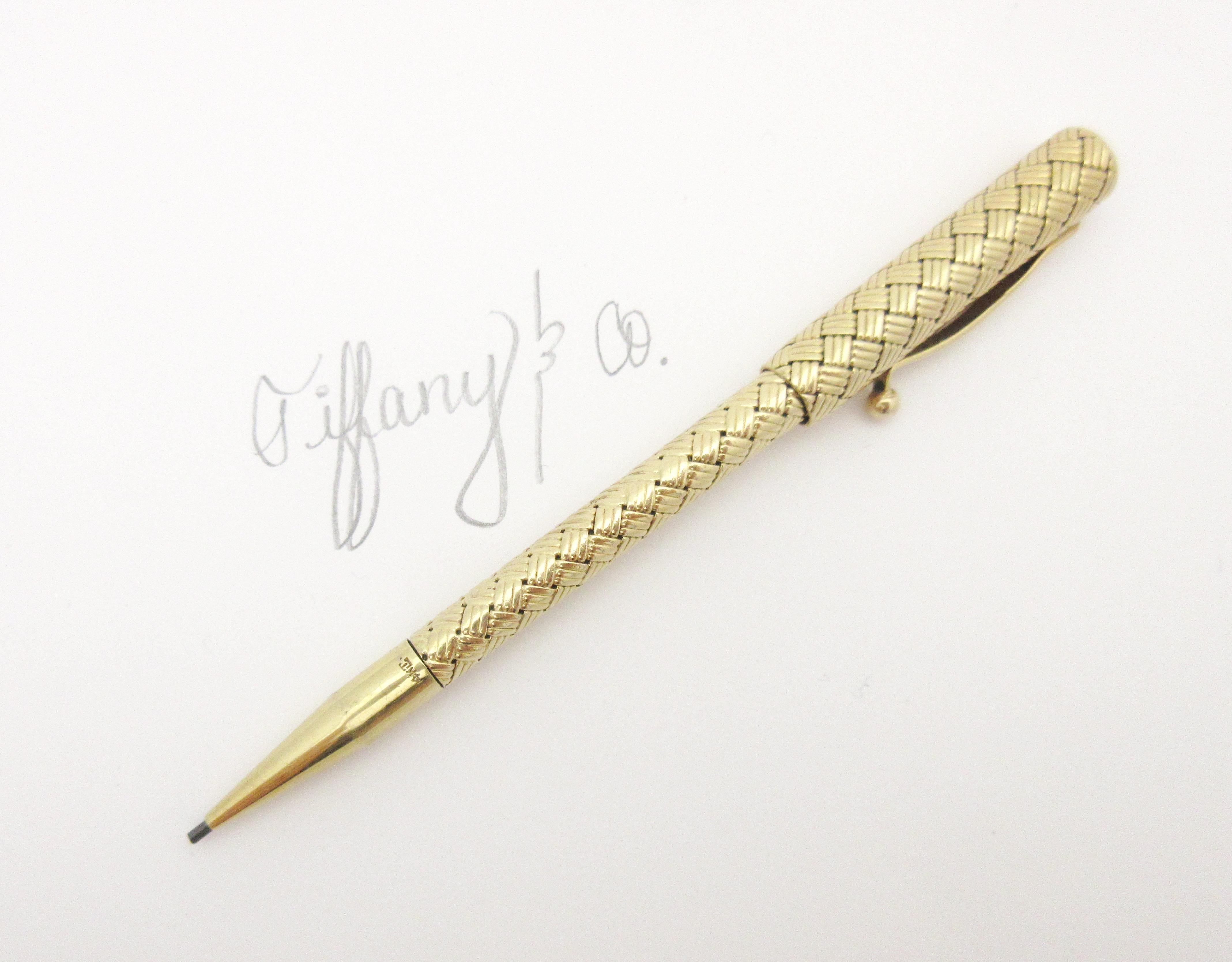 This rare piece is an original from Tiffany & Co. dating to the 1950s.

This solid 14 karat gold writing utensil is a double-ended implement with both a pen and functioning pencil. The piece features a stunning basket weave texture from the body of