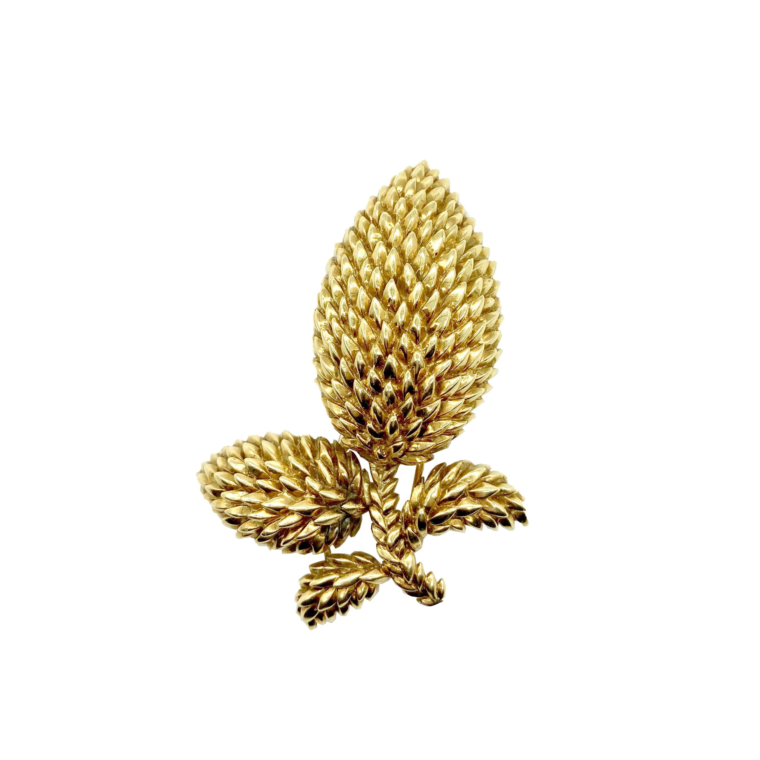 A retro brooch by Tiffany & Co. featuring a foliate design in textured yellow gold. Circa 1940s.