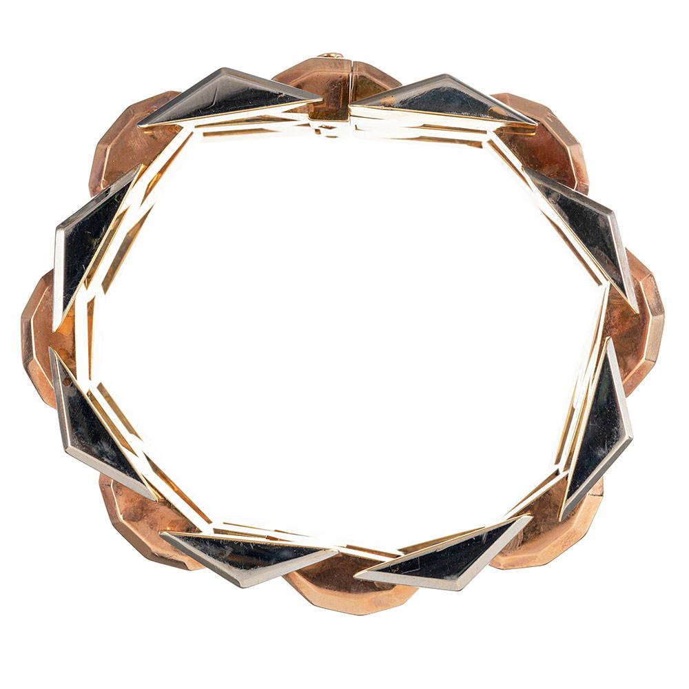Faceted links of 18 karat rose gold are alternated with engraved links of 18 karat white gold, while the underside is finished in 18 karat yellow gold. This is a most uncommon means of creating such a bracelet and requires elevated skill. The