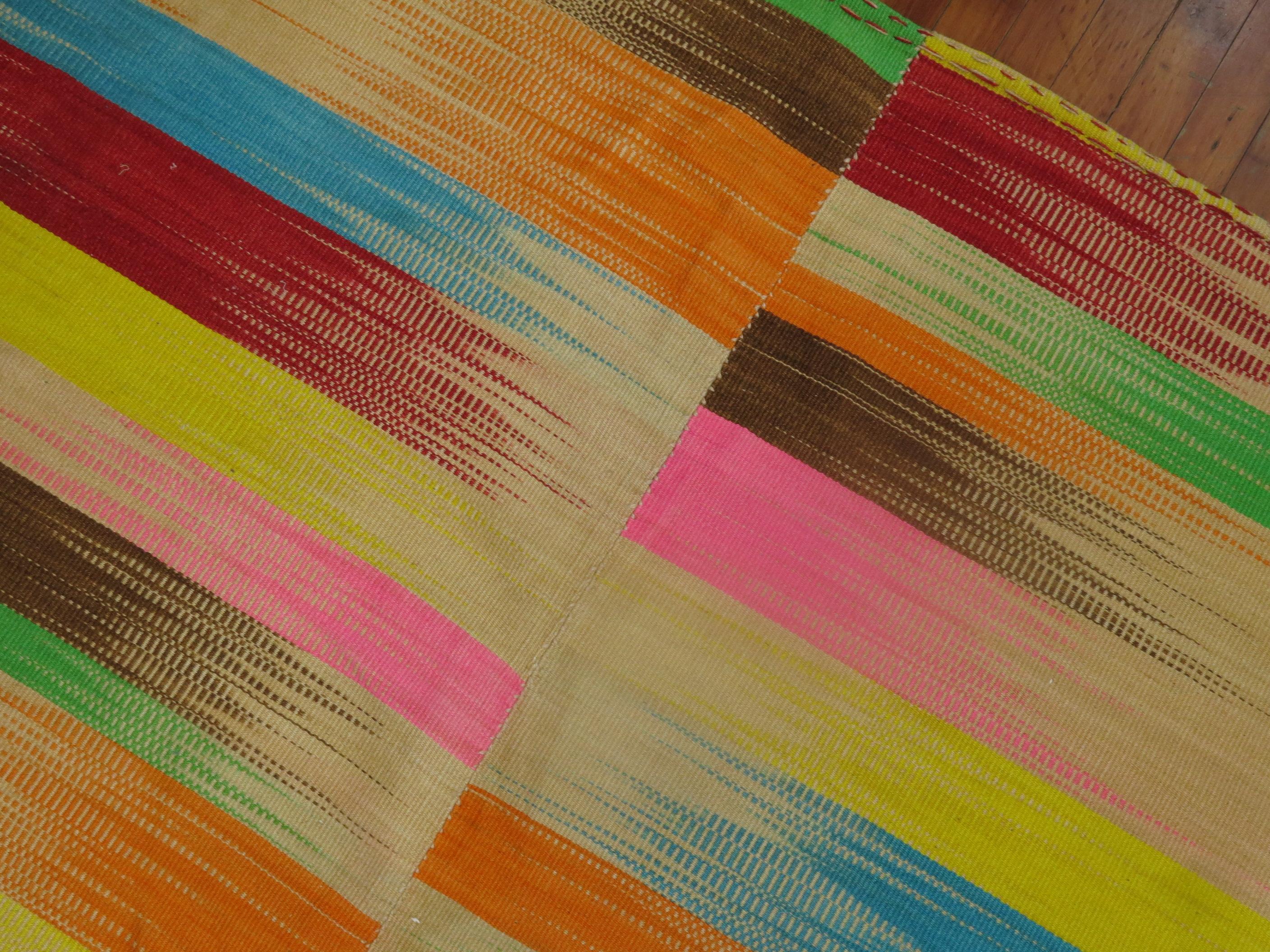 A one of a kind one-off Turkish Kilim featuring a rainbow color palette.