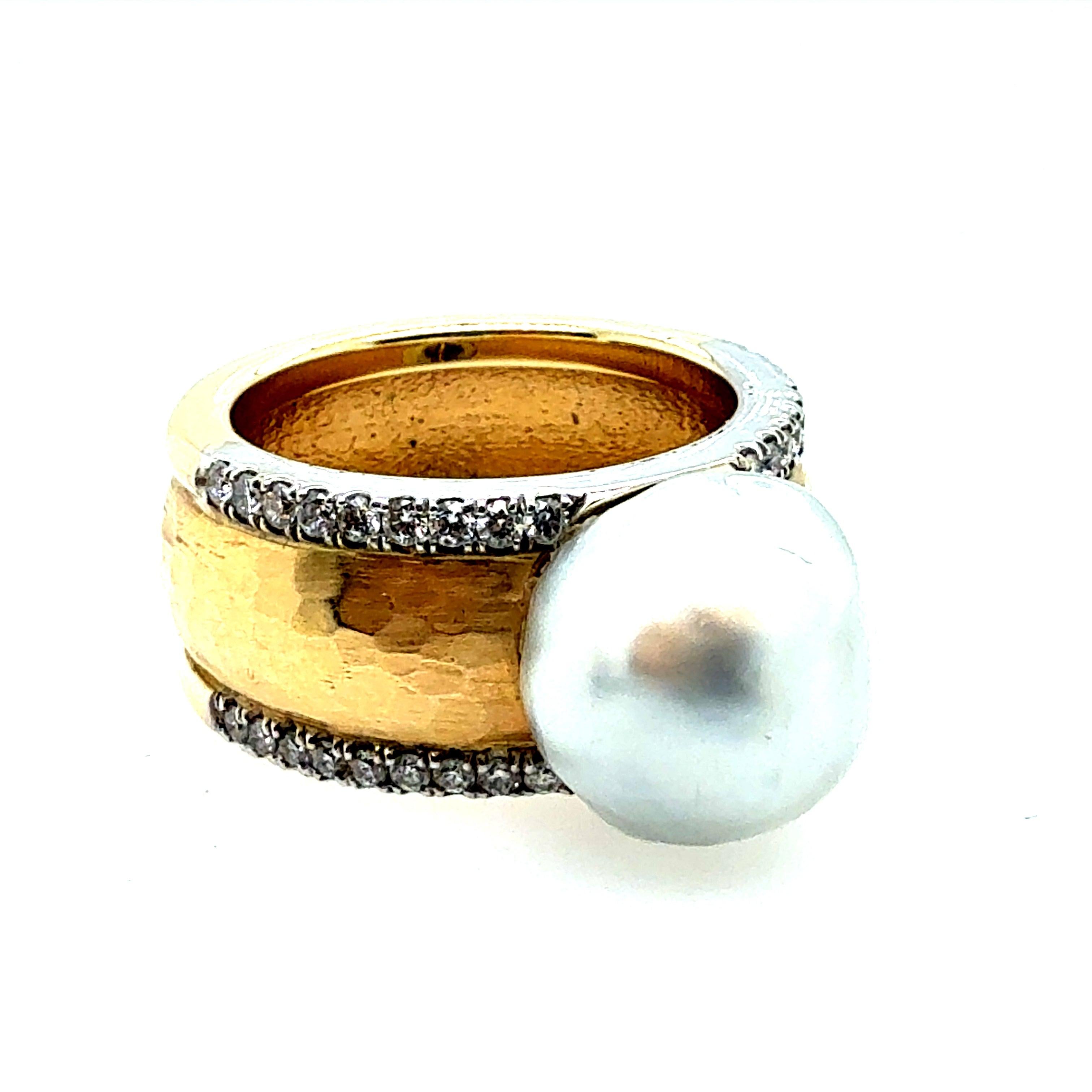 Retro two-tone gold statement ring featuring a high-luster 11 mm South Sea pearl, accented by 36 natural colorless diamonds set in white gold, totaling approximately 0.40 carats. 
The yellow gold band has a beautiful hammered texture and measures