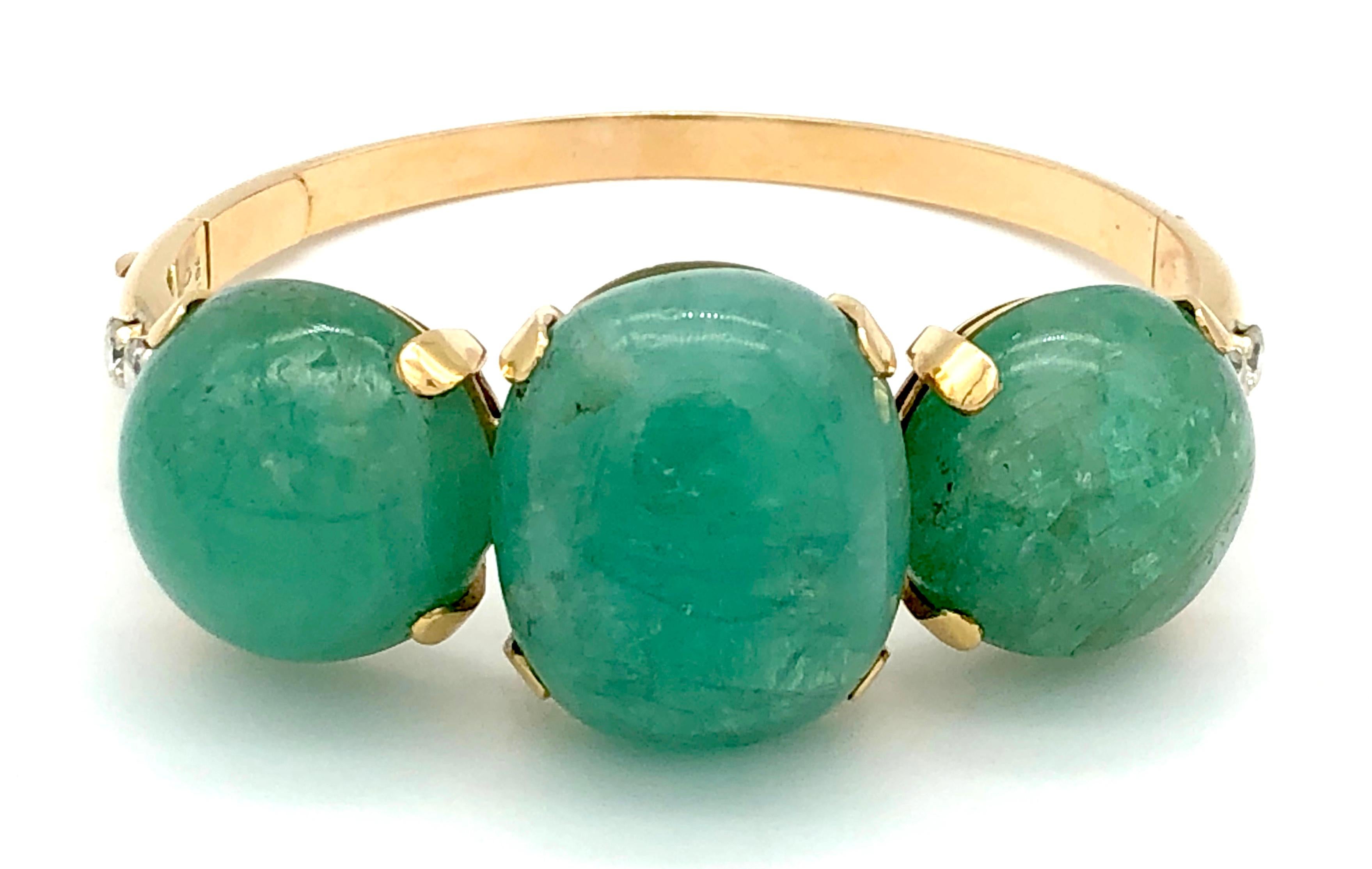 You can bring the freshness of spring to your life with this wonderful and stylish 1930/40s chunky gold bangle with three large emerald cabochons, one oval and two round. The emeralds are mounted with wide claws, to either side the bangle is set