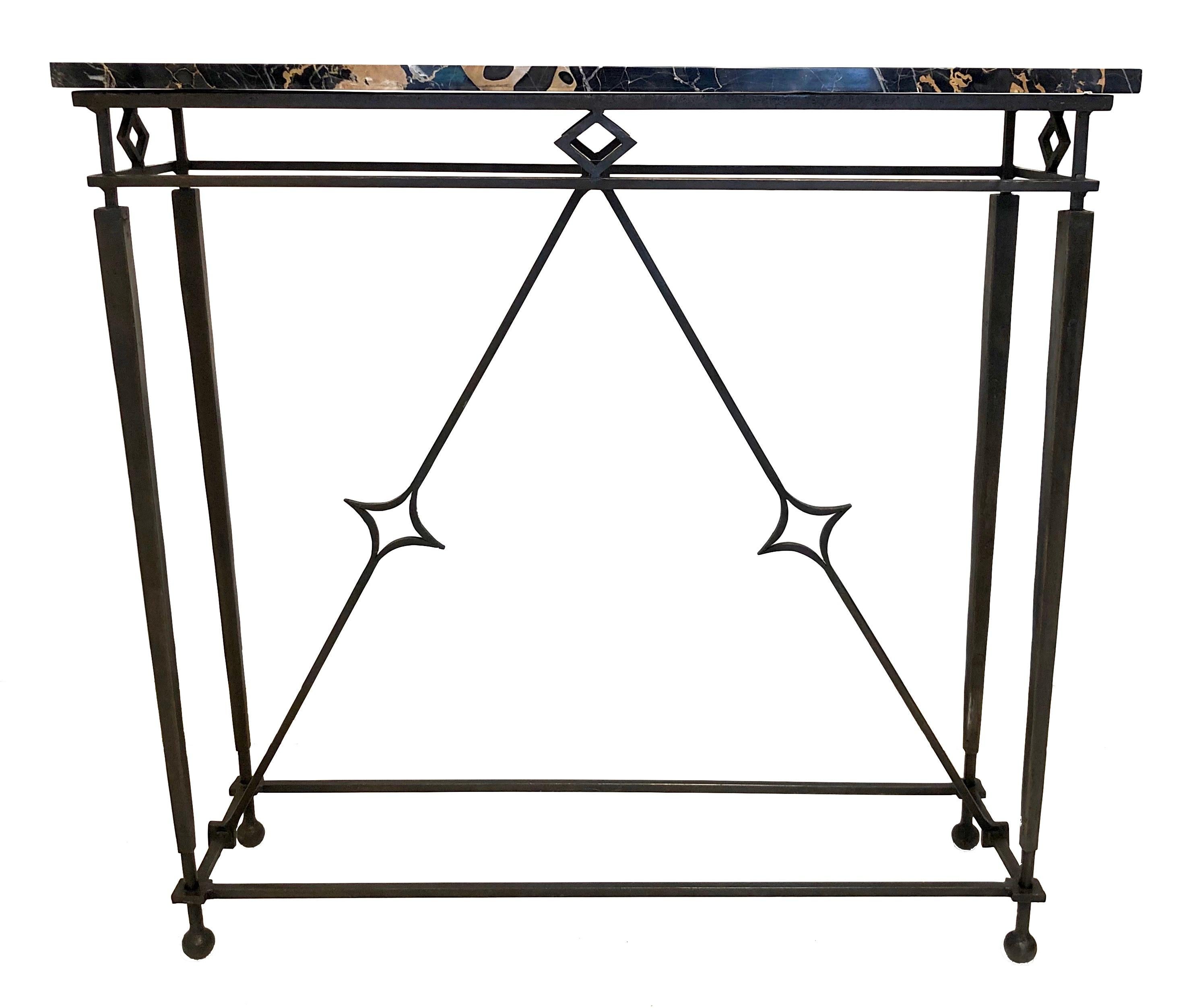 This stylish elegant console-table was made in Paris, circa 1940.
The rectangular marble top, made out of Porto Oro marble, stands on four square tapered legs in patinated iron with ball feet. Under the top are four rhombus-shaped decorations. All