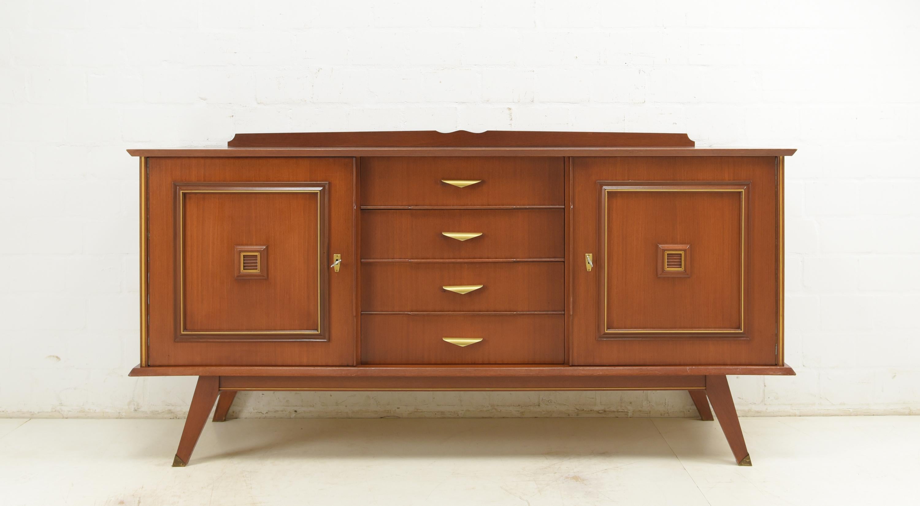 Sideboard restored midcentury 50s 60s vintage mahogany

Features:
Two-door model with 4 drawers
Very high quality processing
Drawers pronged
Shelves with inlaid edge on the inside
Original fittings and decorative elements made of anodized