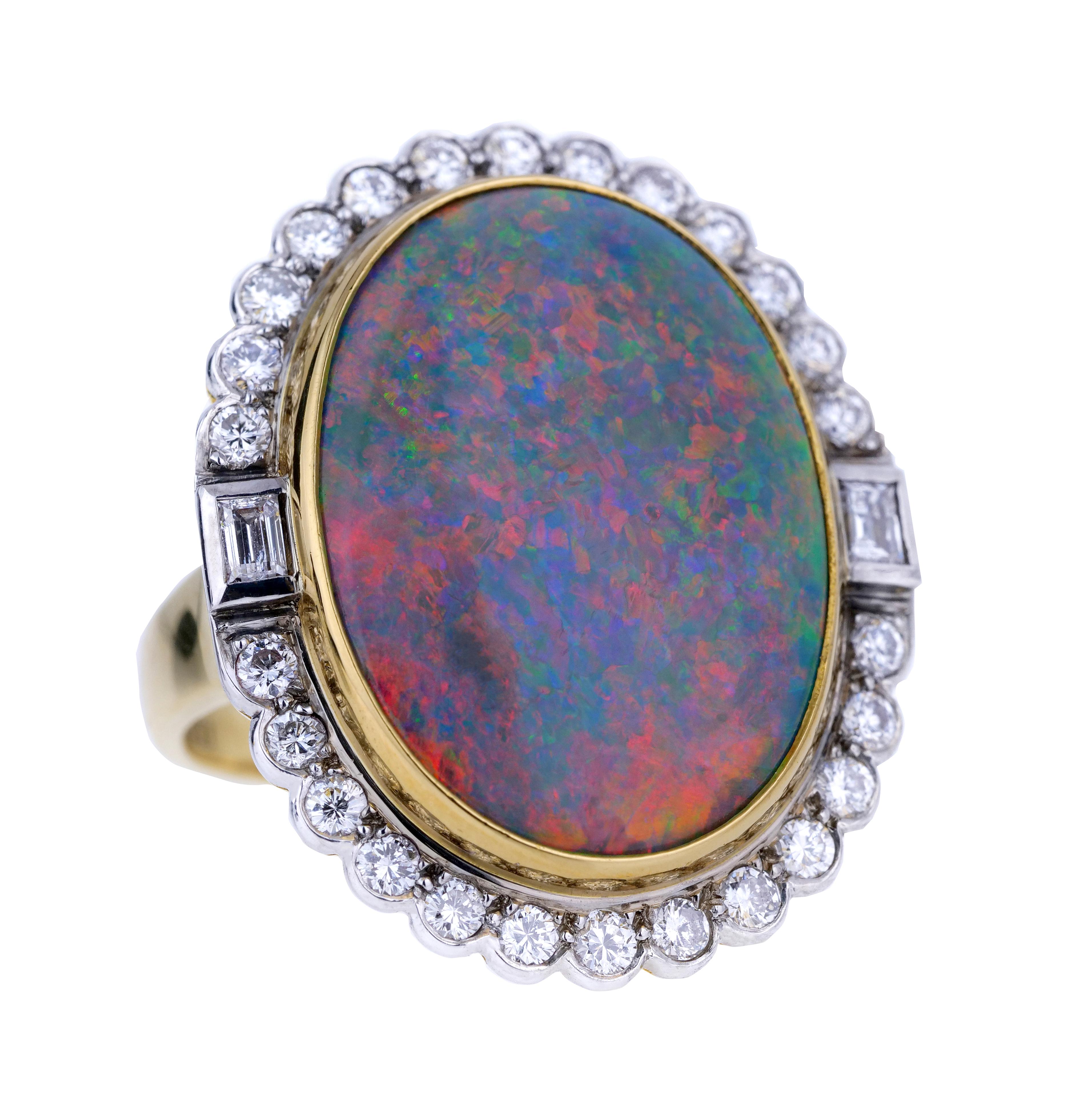 A stunning 18 carat gold Australian opal and diamond dress ring , the natural opal shimmering with vibrant shades of red, orange and green with hints of yellow and electric blue, all on a pale blue background bordered by bright white round brilliant