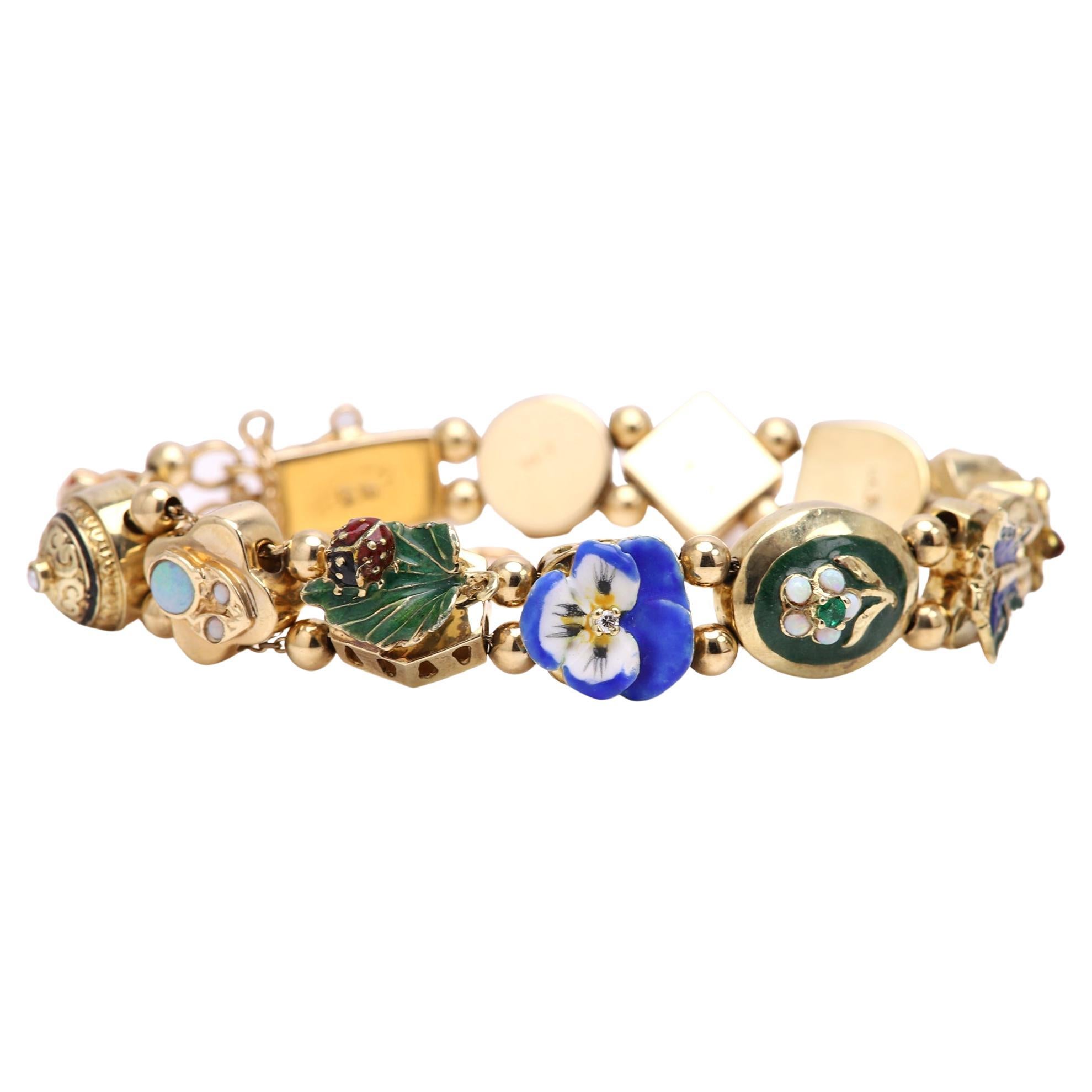 pre owned but in excellent condition retro vintage slide bracelet
14k yellow gold total 35 grams
12 slides total length 7' inches
circa 1940
slides include am emerald and topaz stone and serval enamel pieces.
every slide is stamped 14k
extra
