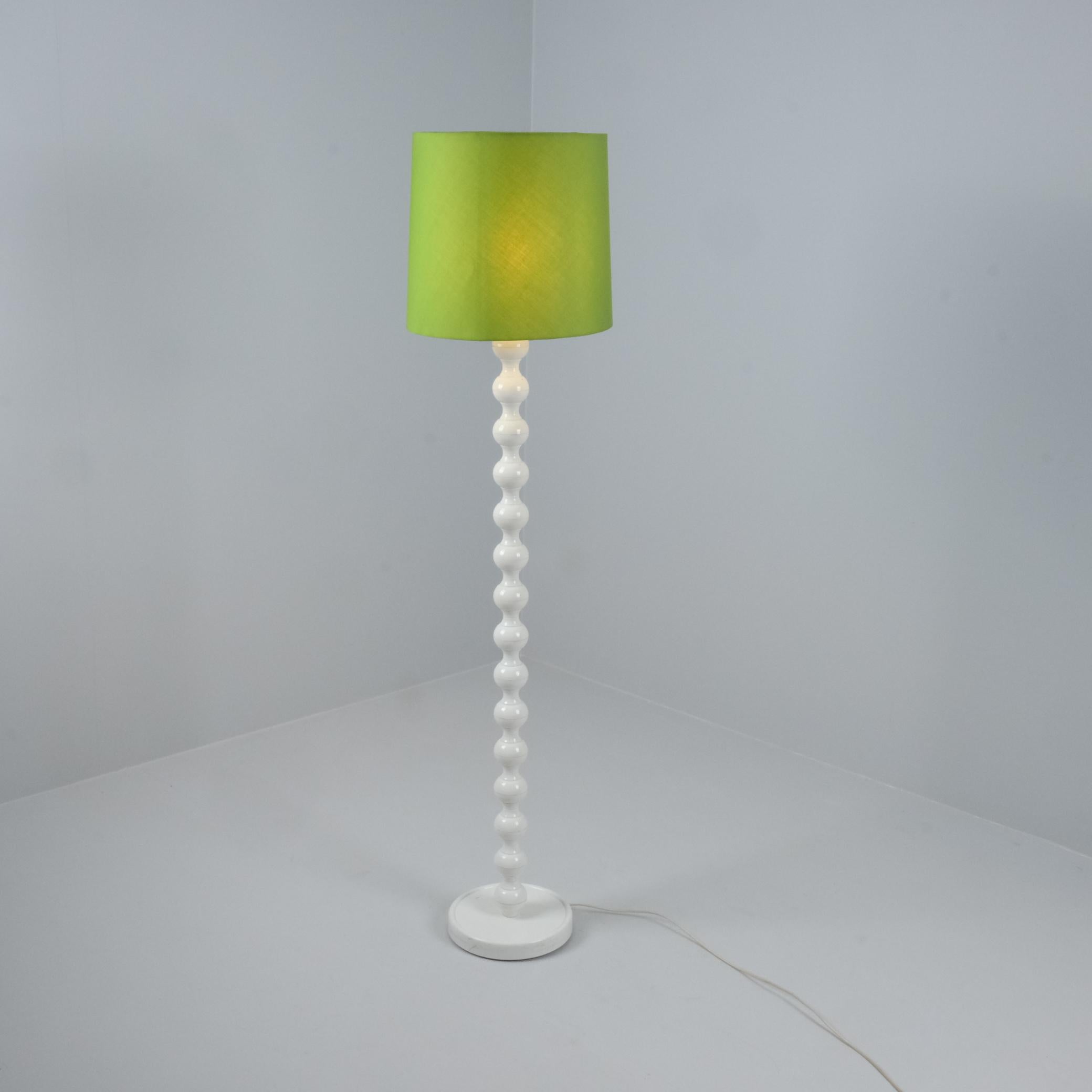 Una preciosa lámpara de pie vintage blanca y verde fabricada por IKEA en los años 70. La lámpara tiene un pie de plástico blanco con un bonito diseño retro, combinado con una pantalla de tela verde lima. La lámpara encajará perfectamente en