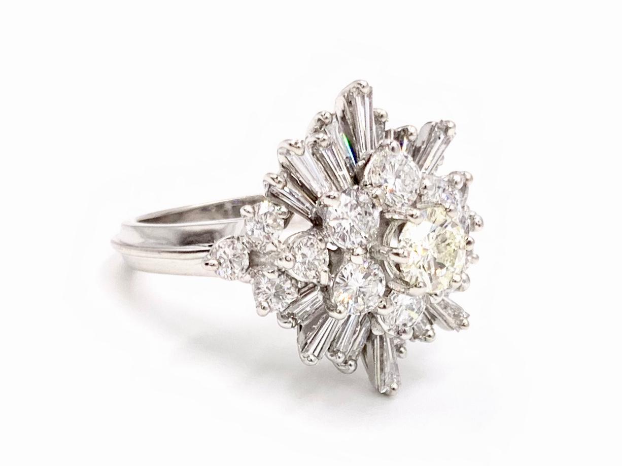 A truly gorgeous retro diamond cluster ring with an eye-catching star shape design. This 14 karat white gold ring is a unique combination of a ballerina style ring and a vintage cluster design with the perfect mix of round brilliant and baguette cut