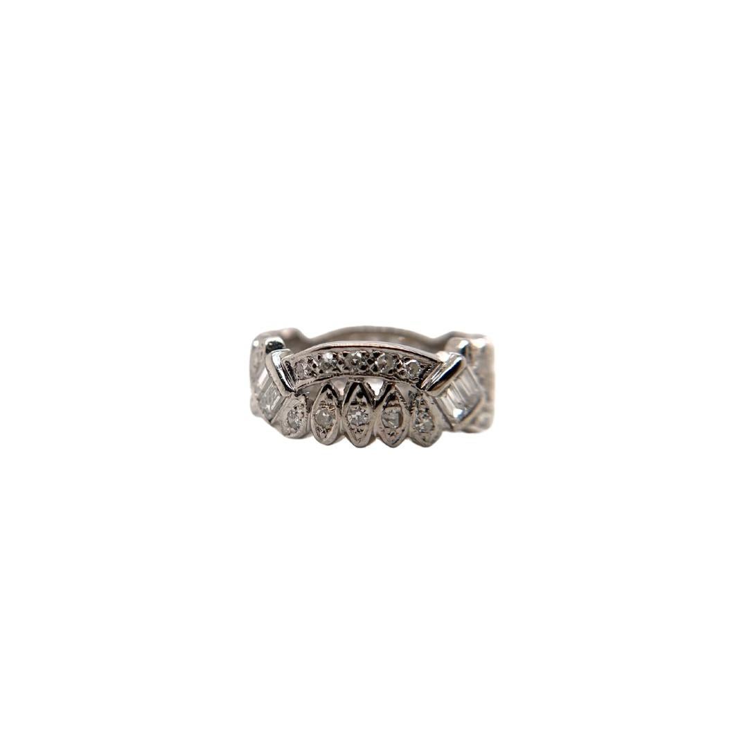 This piece was crafted sometime during the Mid Century design period (1940-1960). This exquisite ring seamlessly blends vintage charm with timeless elegance. This breathtaking eternity band showcases an array of diamond cuts that dance and shimmer