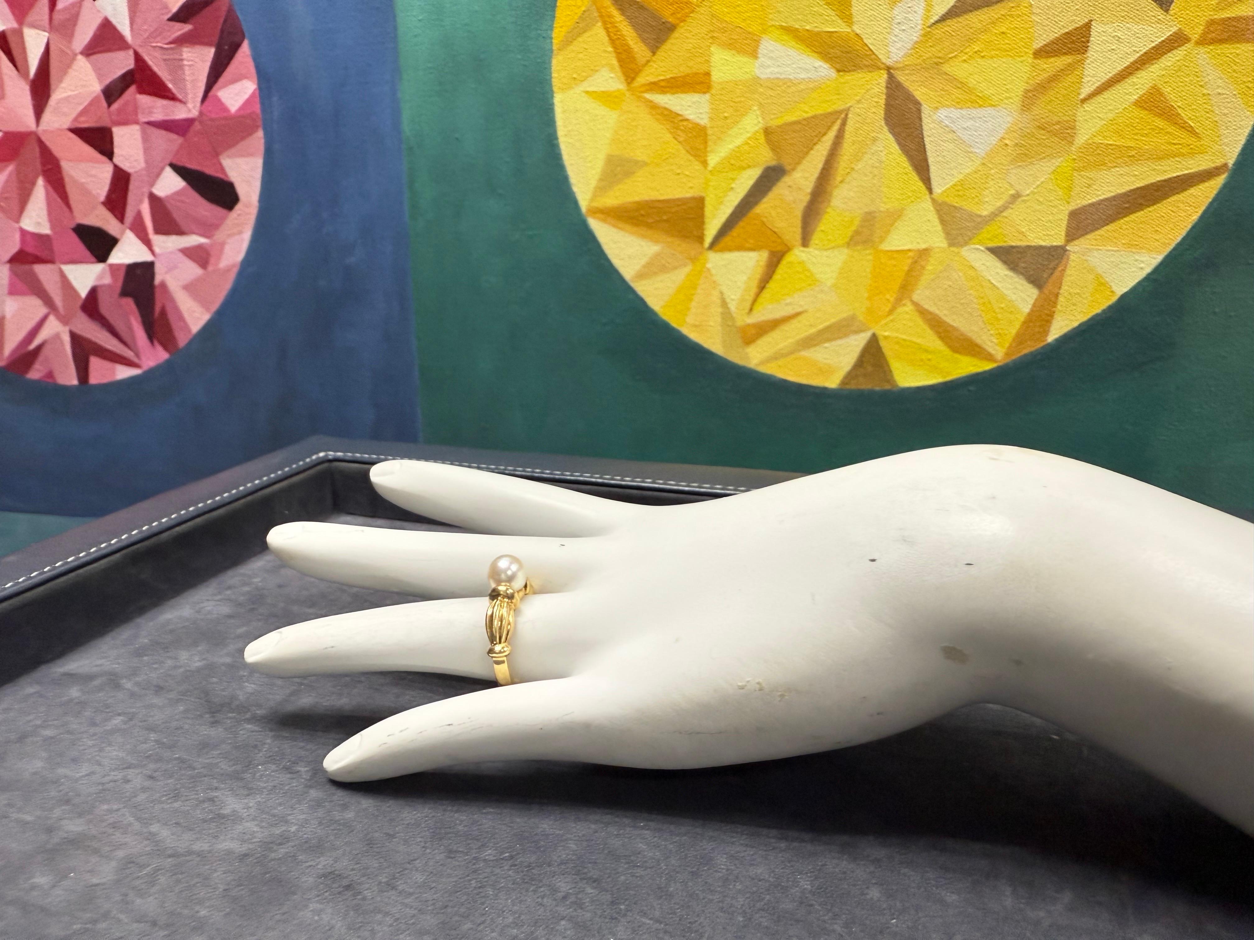 Cette bague rétro classique en or jaune 18 carats est ornée d'une perle de culture très brillante mesurant environ 7 mm de diamètre. Le design s'élève à 5 mm du haut et se rétrécit jusqu'à environ 2,5 mm au bas de la bande.

Réalisée en or jaune 18