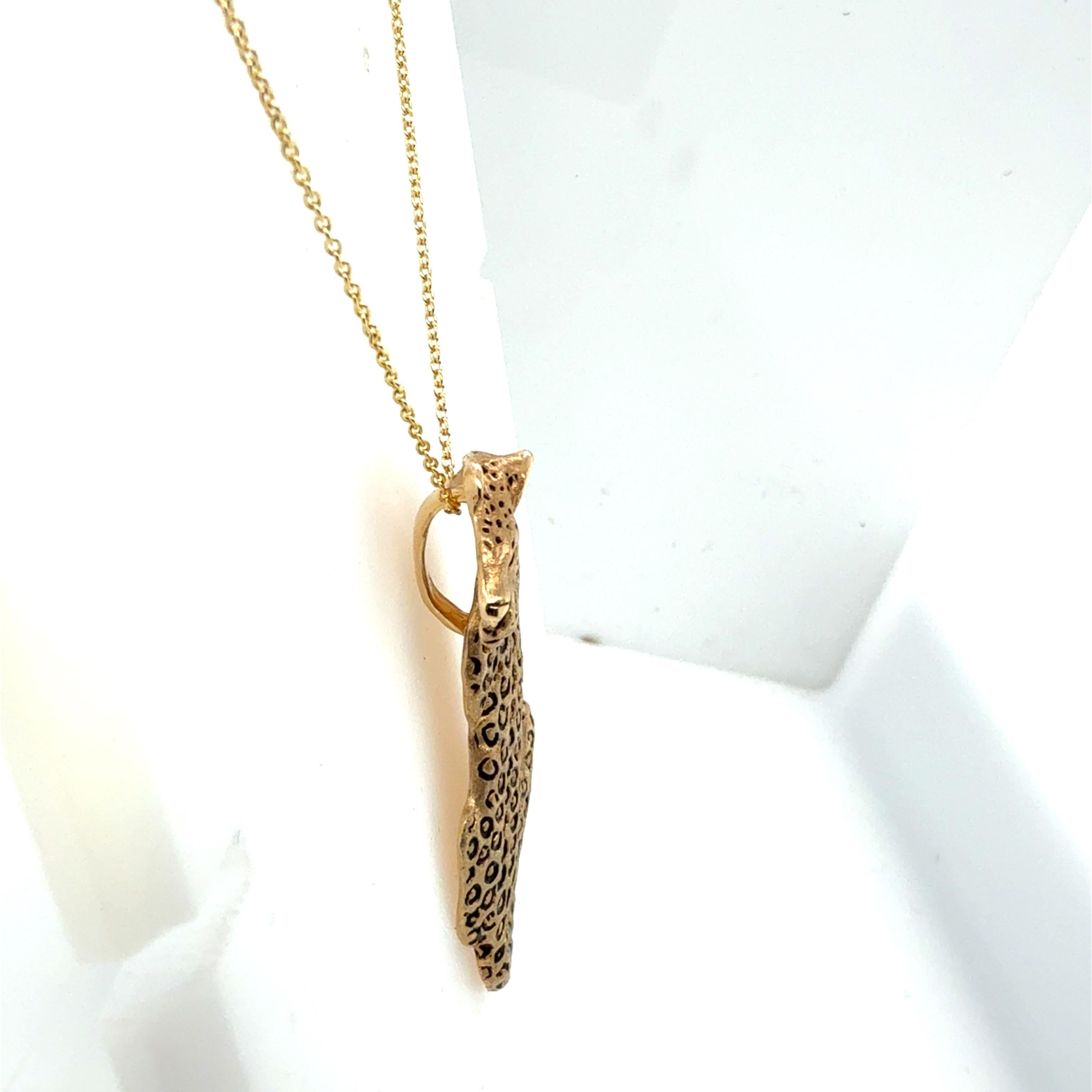 Pendentif rétro de Gayle Knight, finement réalisé en or jaune 14 carats et conçu sous la forme d'un léopard élancé. Cette pièce en édition limitée est numérotée 28 sur 300, ce qui souligne son importance en tant que pièce de collection.

Le