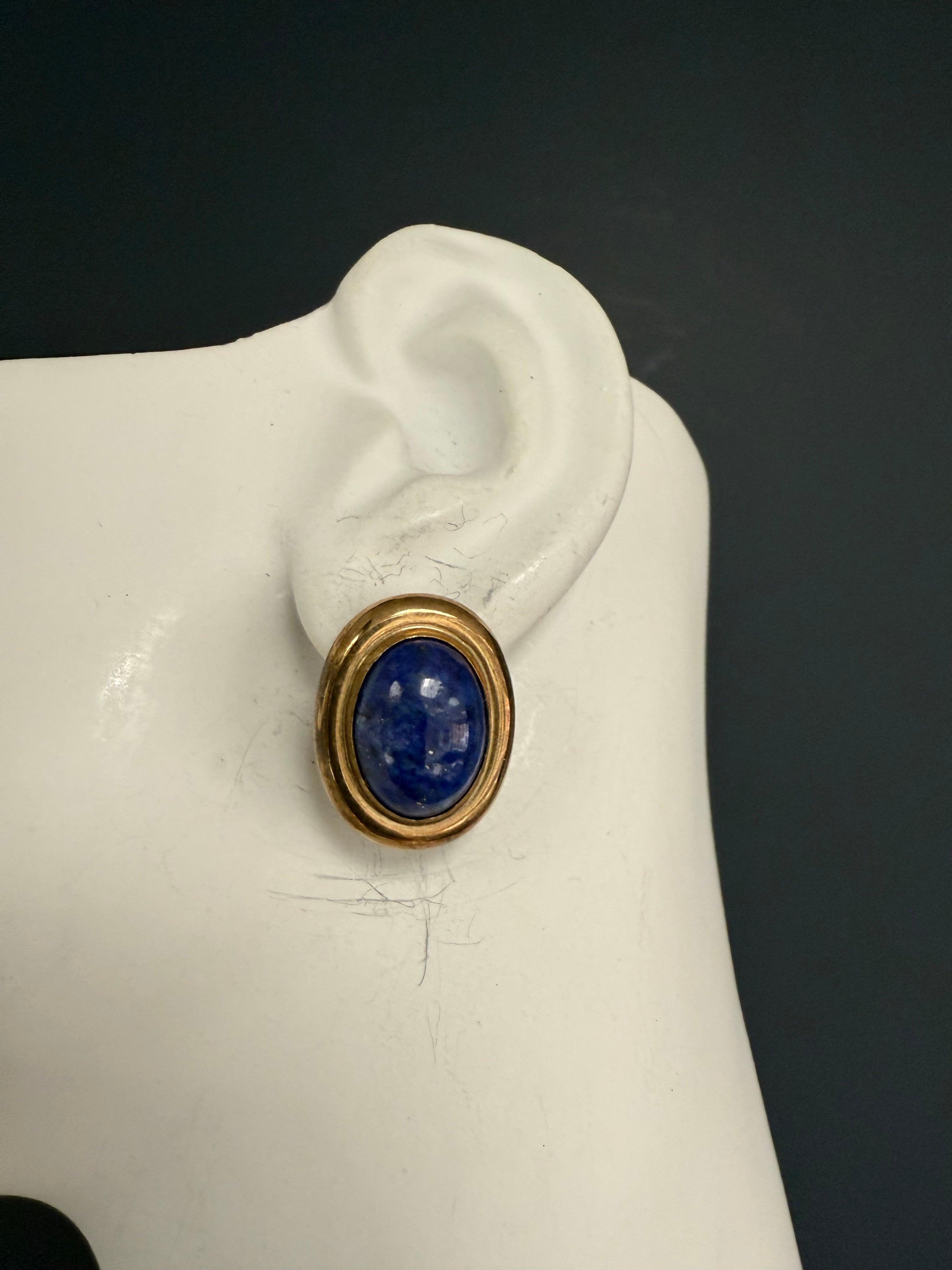 Retro yellow gold oval statement earrings featuring rich blue lapis lazuli cabochons at the center, each measuring approximately 15.5 x 11.5 mm. The overall dimensions of the earrings are about 23 x 18 mm, with a total weight of 6.6 grams.
 
Three