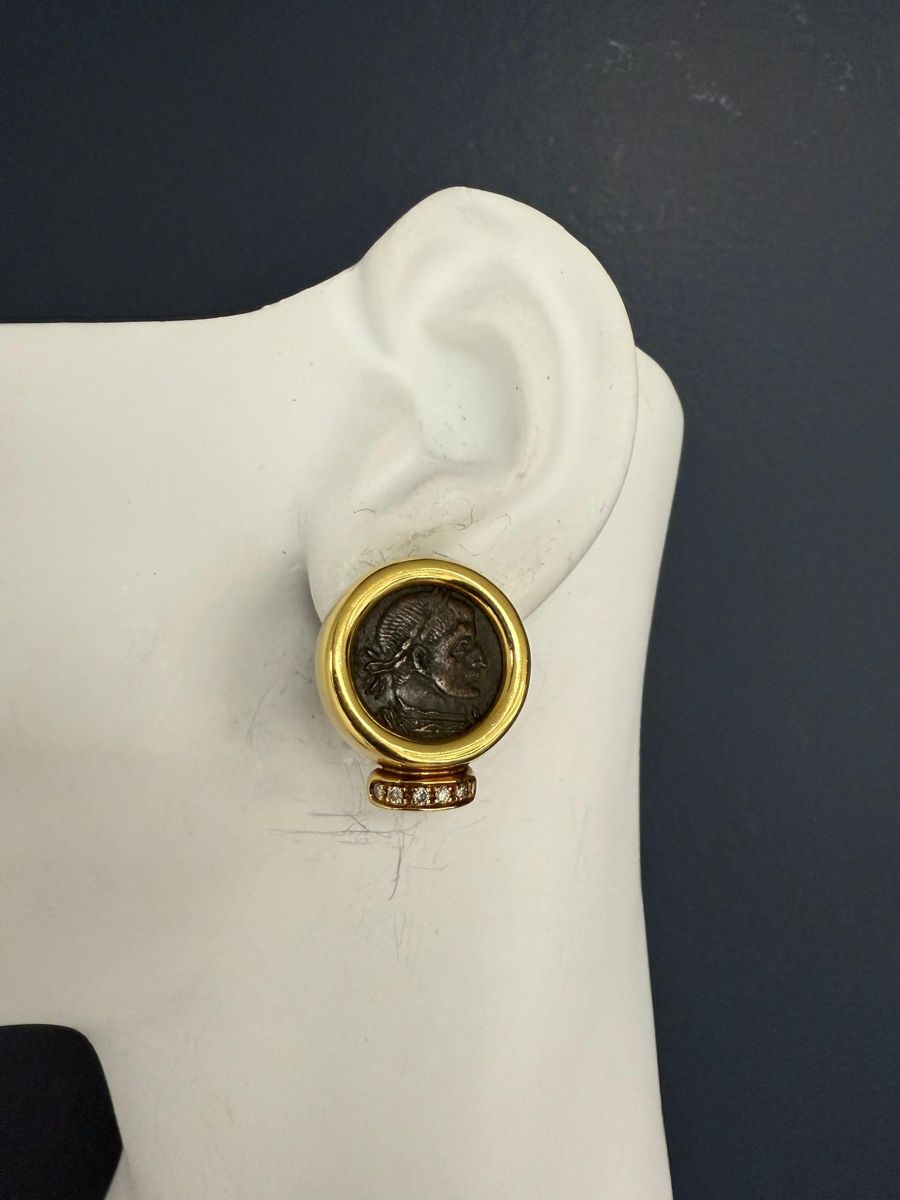 Elegante Ohrringe aus 18 Karat Gelbgold mit echten römischen Konstantin-Münzen aus Bronze, umrahmt von 12 farblosen runden Brillanten. Jeder Ohrring misst etwa 24 x 21 mm und ist fein gestempelt mit 750 und OWC. Gesamtgewicht: 23,2 Gramm. Eine