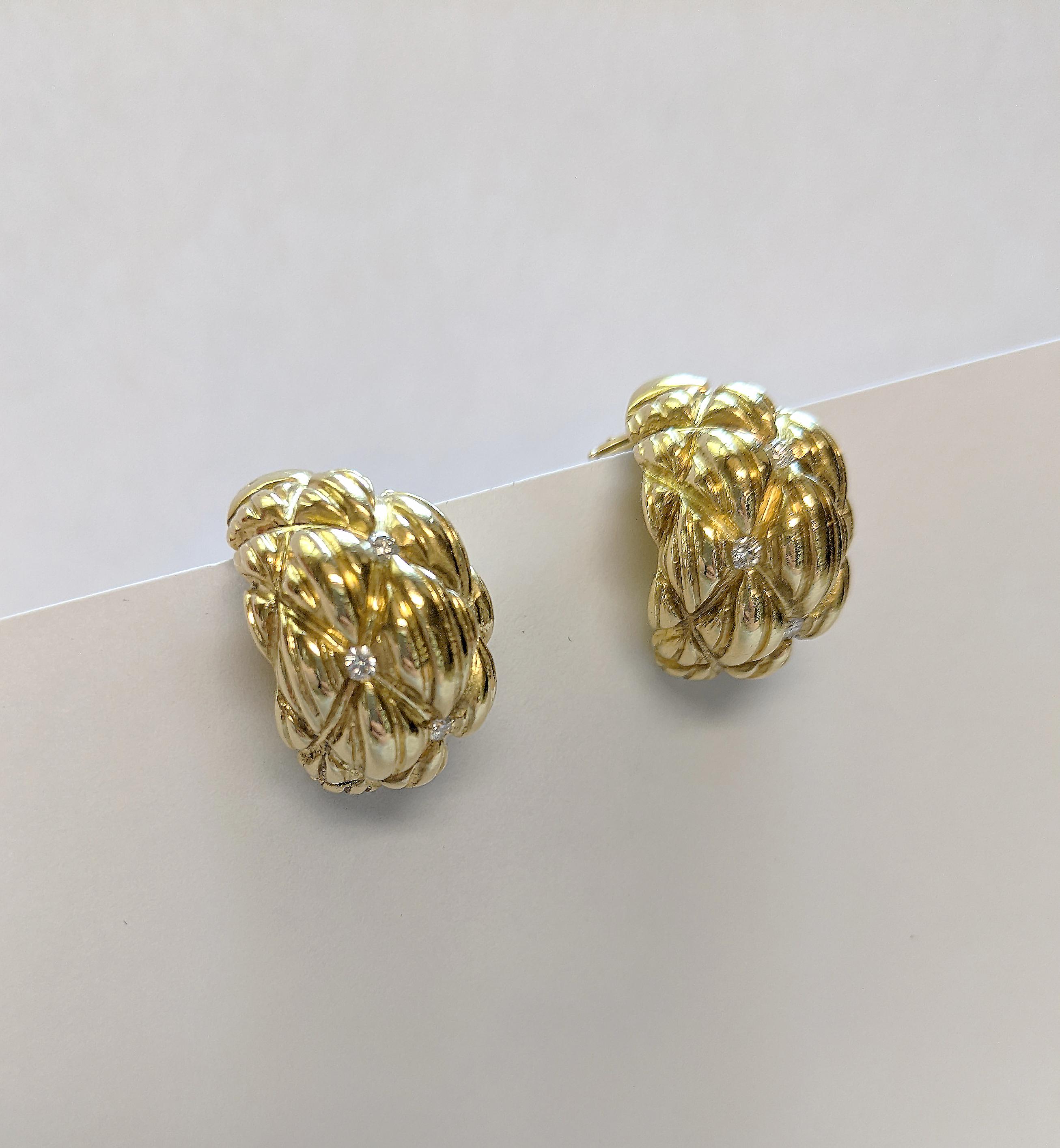 This pair of retro clip-on earrings features a tufted, textured design in the metal work that offers movement and interest. Crafted in sterling silver and topped with vibrant yellow gold plate. A quad of diamonds adorns each earring. 

The earrings