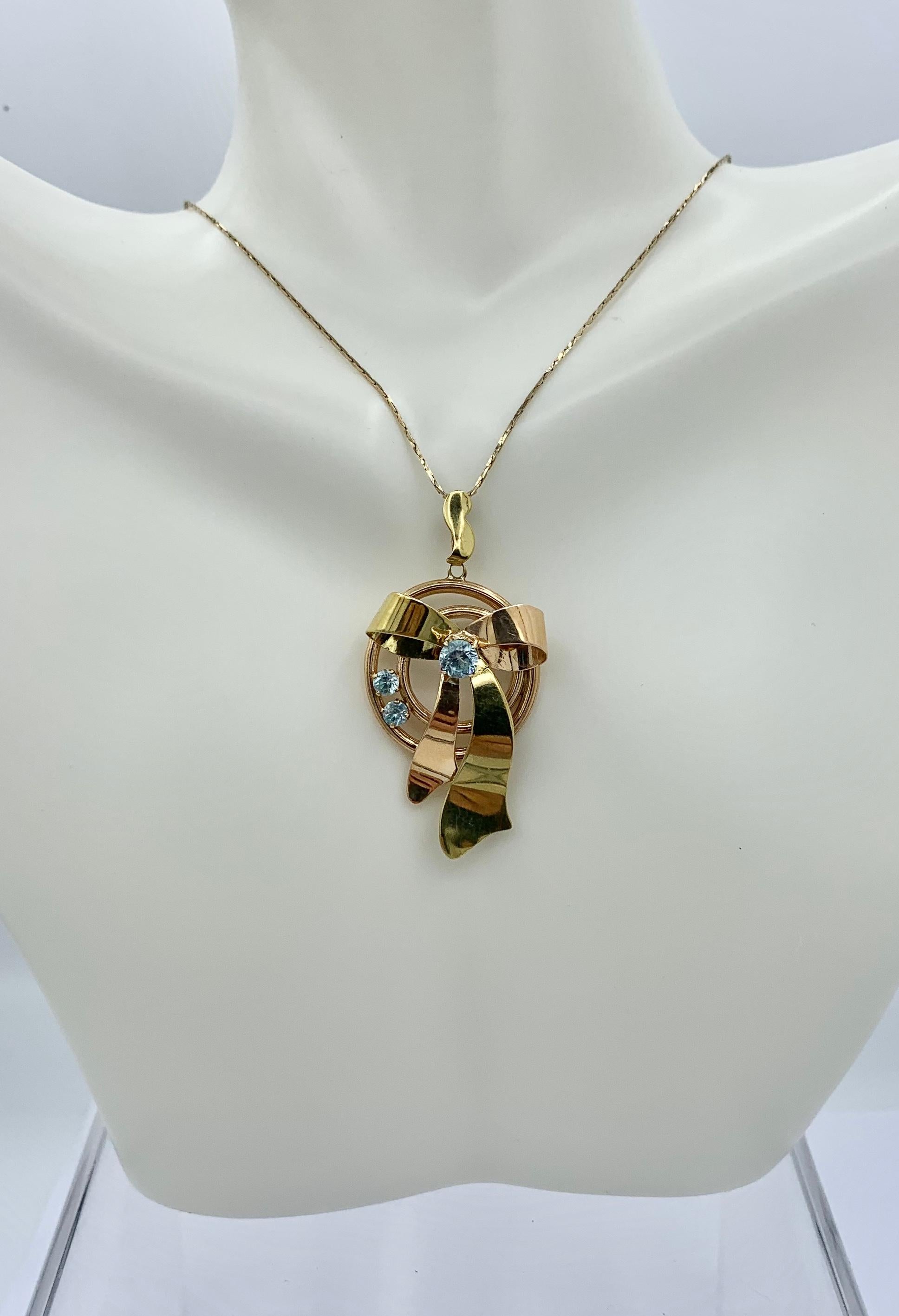 This is a stunning Retro Mid-Century stylized ribbon bow motif pendant set with a three gorgeous round faceted blue Zircon gems in 10 Karat Rose Gold.  Zircons and Rose Gold epitomize the Retro Mid-Century jewels and the color combination of the