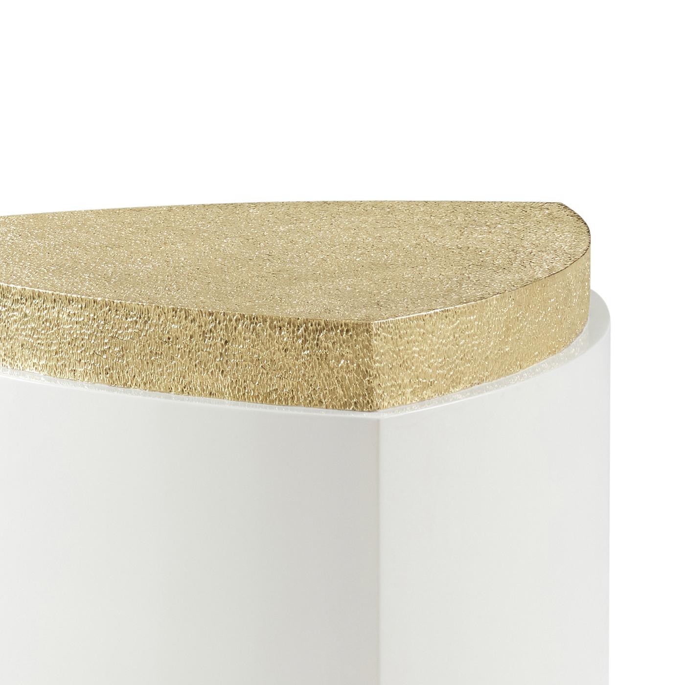 Une pièce d'exception pour tout espace luxueux. Défini par sa forme triangulaire unique aux côtés incurvés - rappelant un triangle de Reuleaux - ce design sculptural est enveloppé d'une laque blanche brillante et ancré par une base et un plateau en