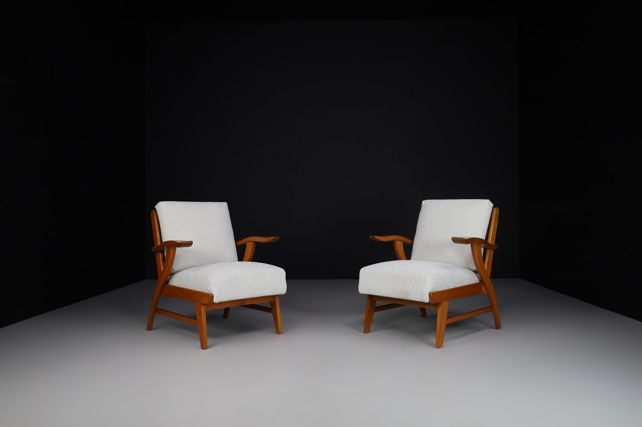 Reupholstered Lounge Chairs with Sculptural Ash Wooden Frame France, 1960s.

Set of two lounge chairs in patinated solid ash and Reupholstered bouclé fabric, France, 1960s. The wood grain is nicely visible, especially on the wide sculpted